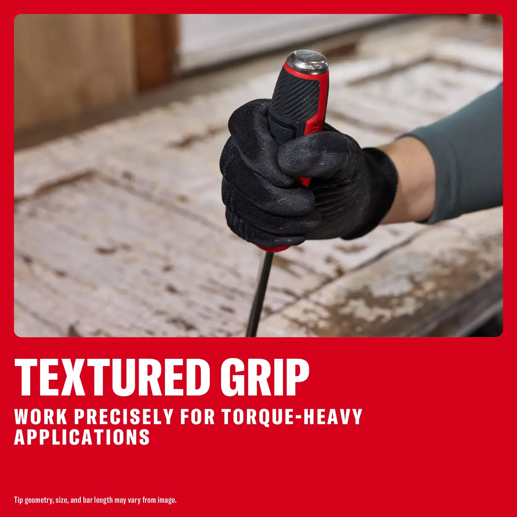 Gloved hand holding a screwdriver with a textured grip, suitable for precise, torque-heavy work on a wooden surface.