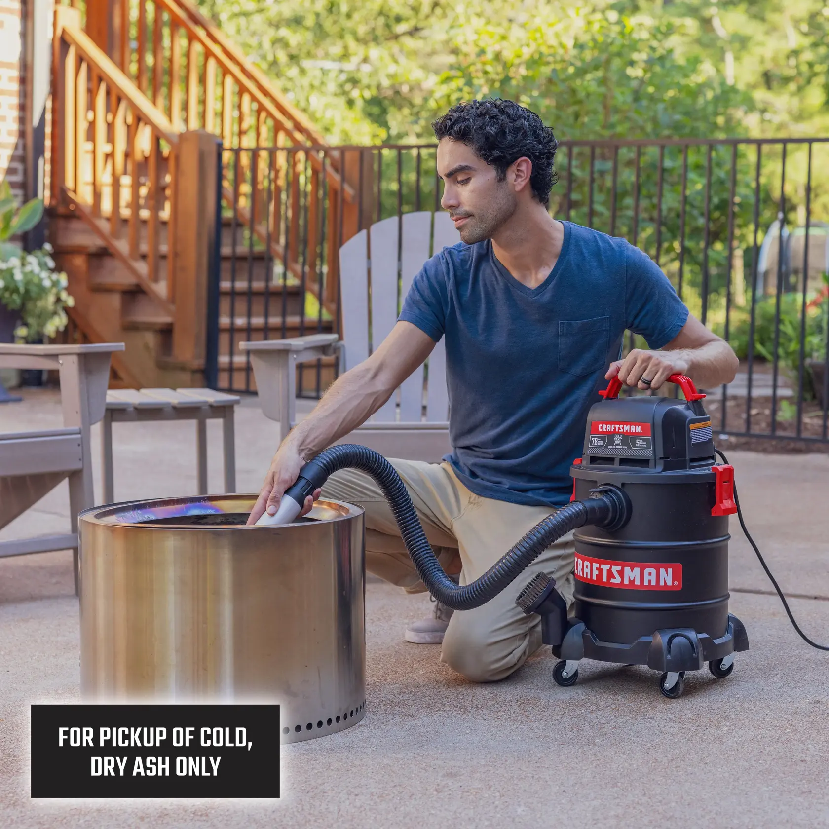 Person uses CRAFTSMAN ash vacuum to clean cold dry ash from a metal fire pit outdoors.