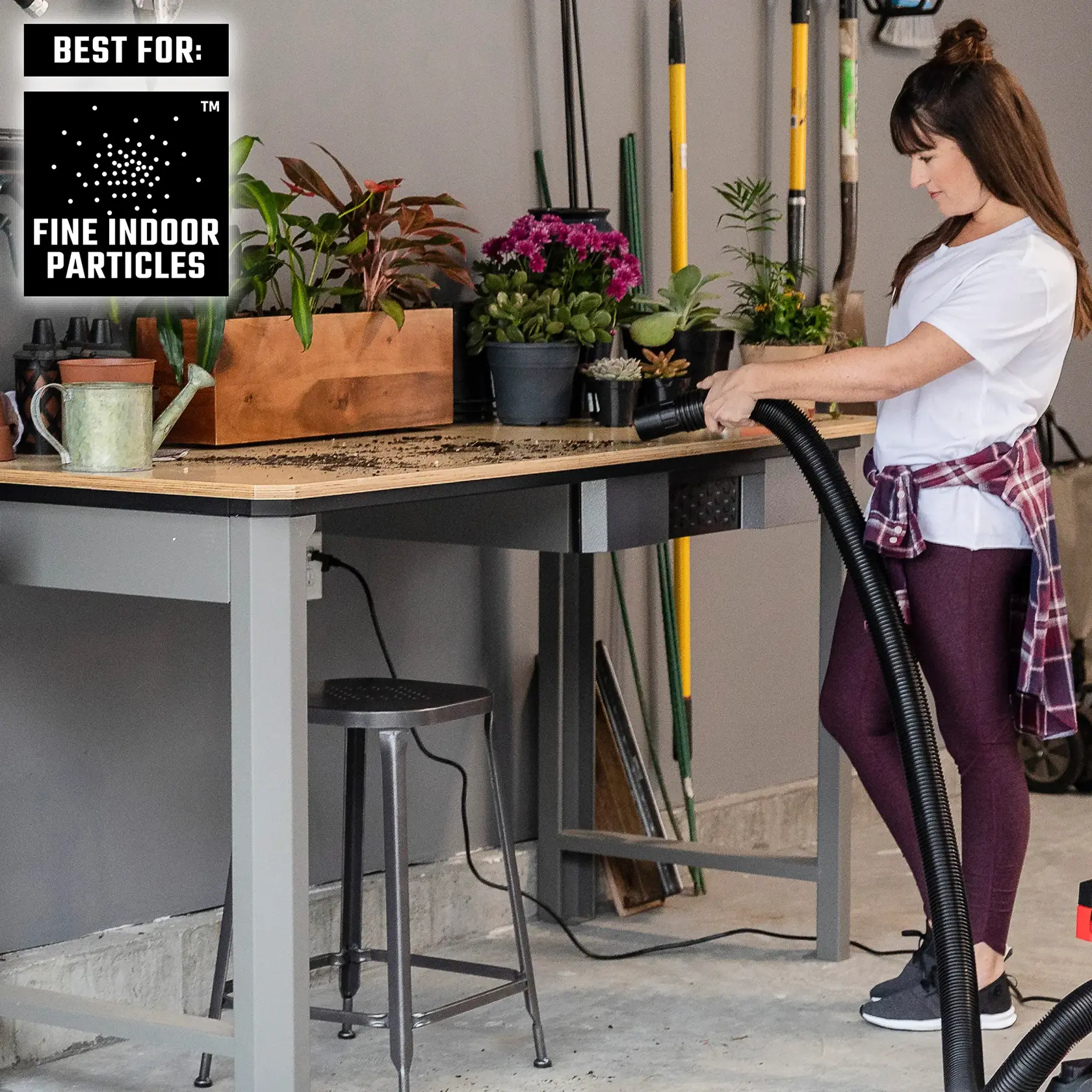 Person cleaning workbench with a CRAFTSMAN wet/dry vacs to clean up fine indoor particles 