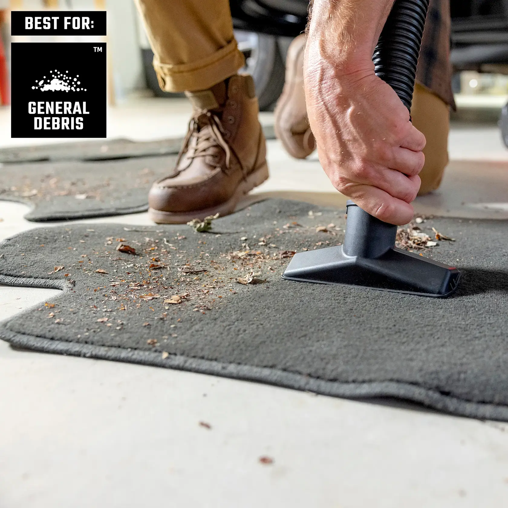 Person vacuuming off dirt of auto floor mats in garage with a wet/dry vac best for general debris