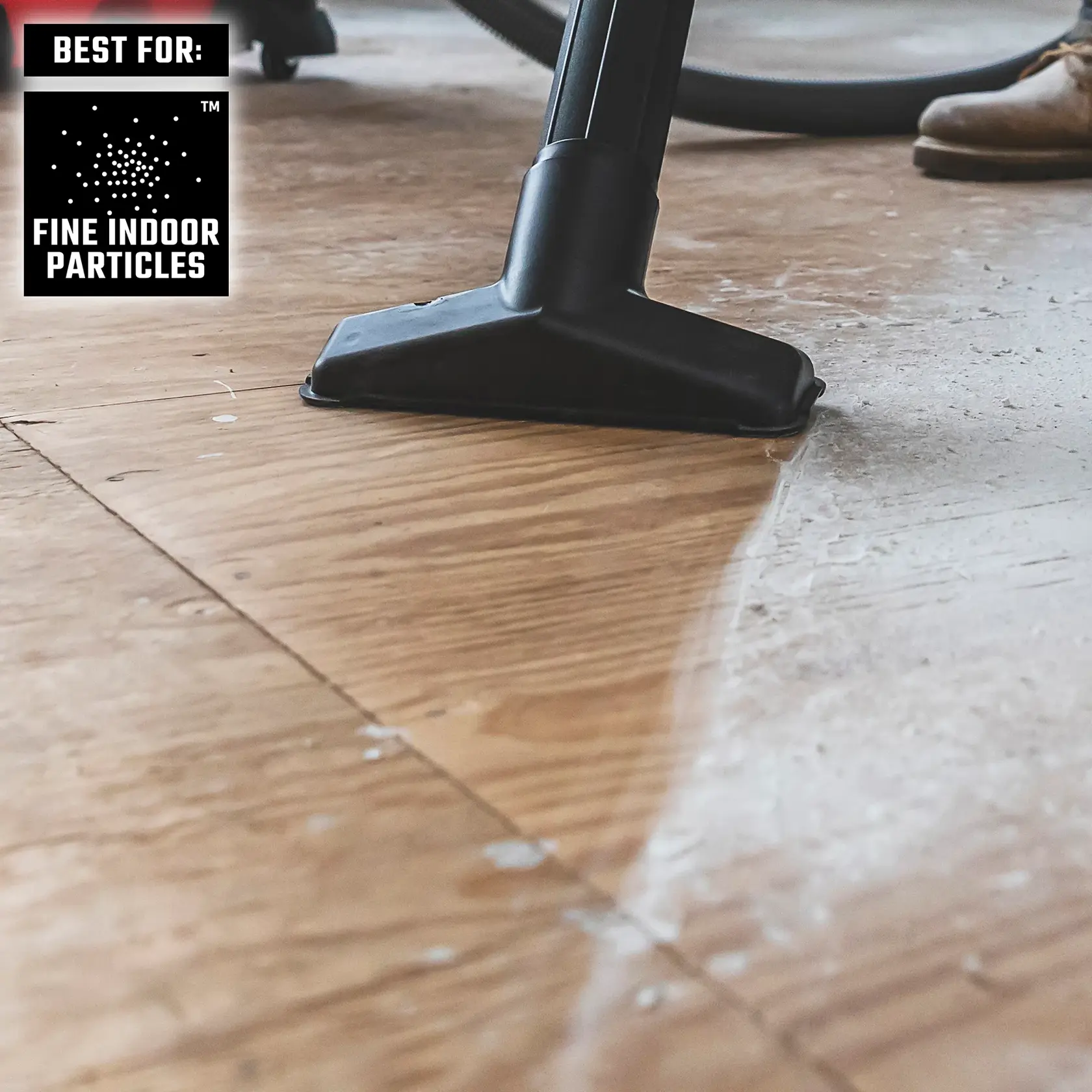 DIYer vacuuming fine indoor particles from wood floor with CRAFTSMAN Wet/Dry Vac and utility nozzle