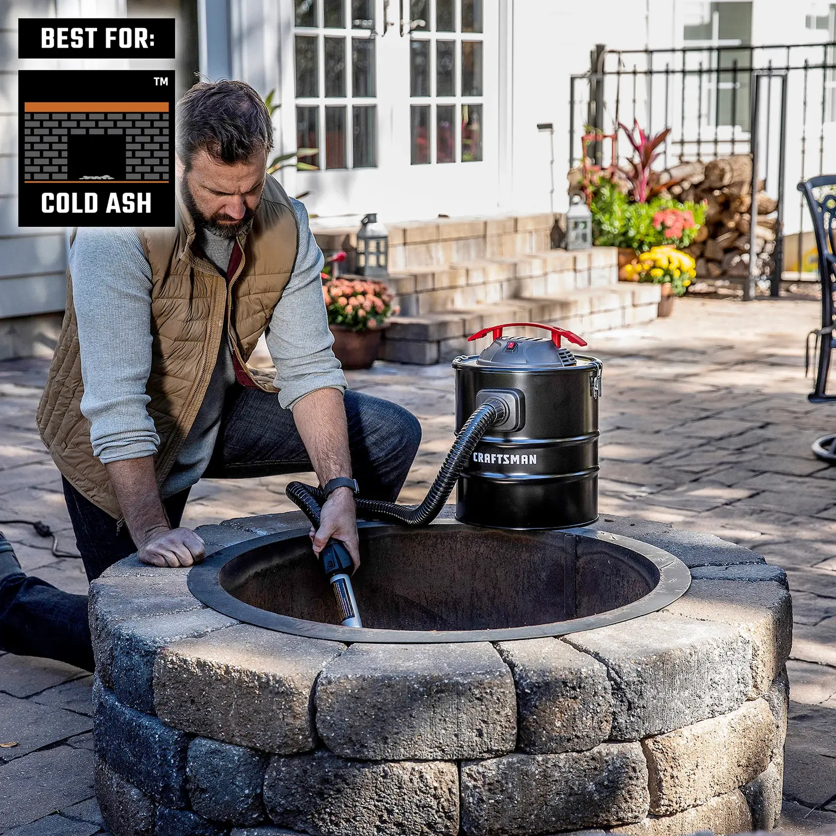 Homeowner kneeled down cleaning cool ash in outside fire pit with CRAFTSMAN Ash Vacuum