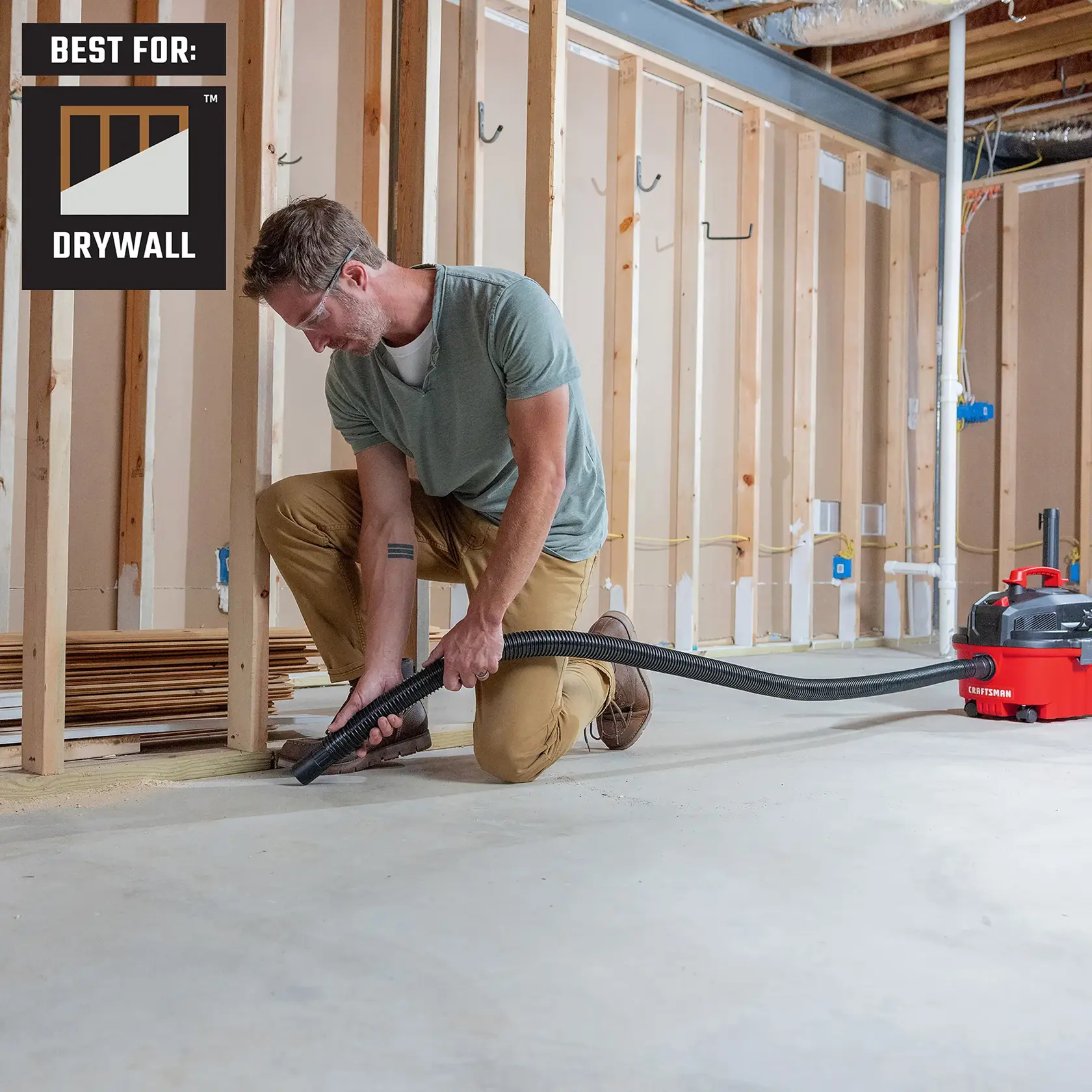 Contractor cleaning up sawdust by newly constructed walls in basement of home with 4 gallon shop vac