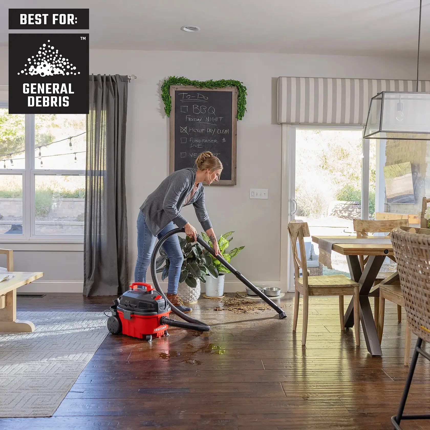 Woman cleaning up plant soil, water on hardwood house flooring with CRAFTSMAN 4 Gallon shop vacuum