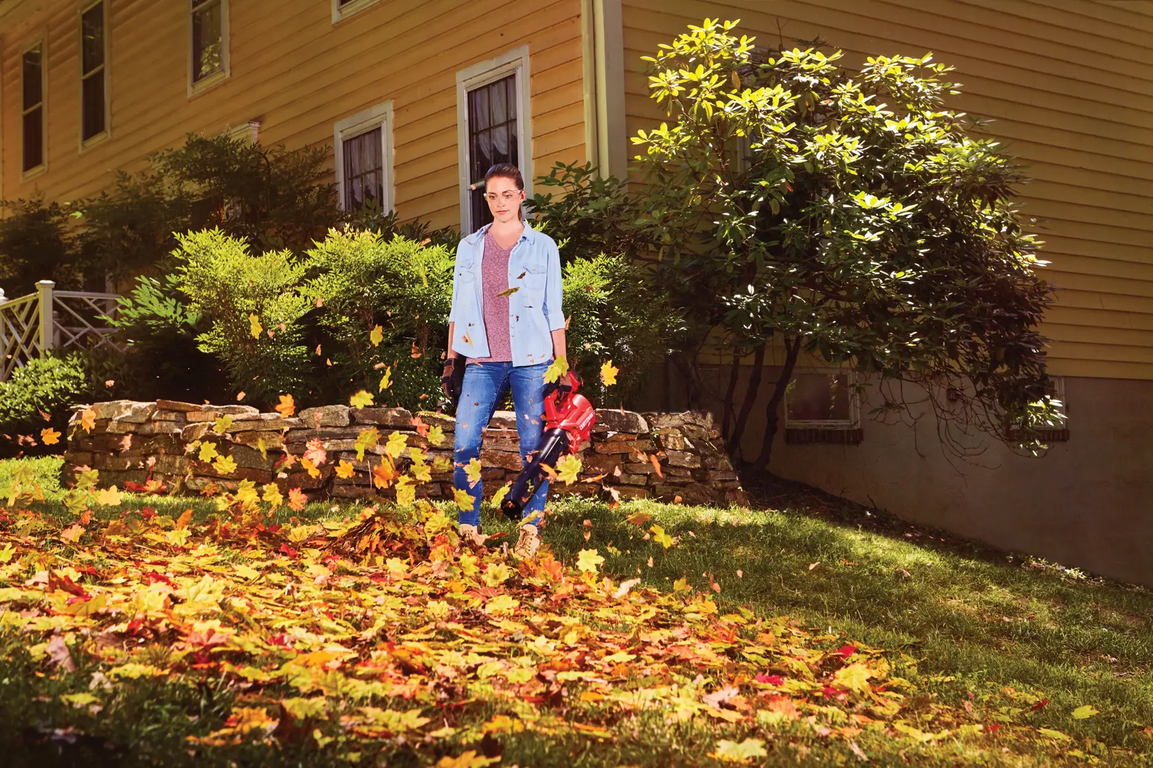 Woman blowing leaves with CRAFTSMAN V20* Cordless Axial Leaf Blower Kit