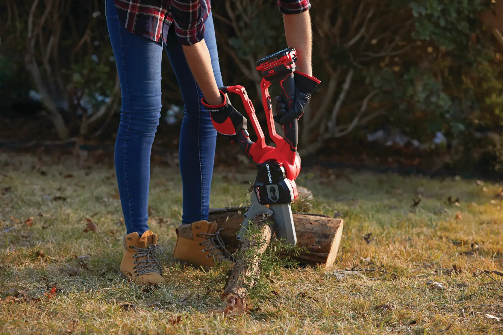 6 inch cordless compact chainsaw lopper kit 2 amp hour being used for cutting wooden log.
