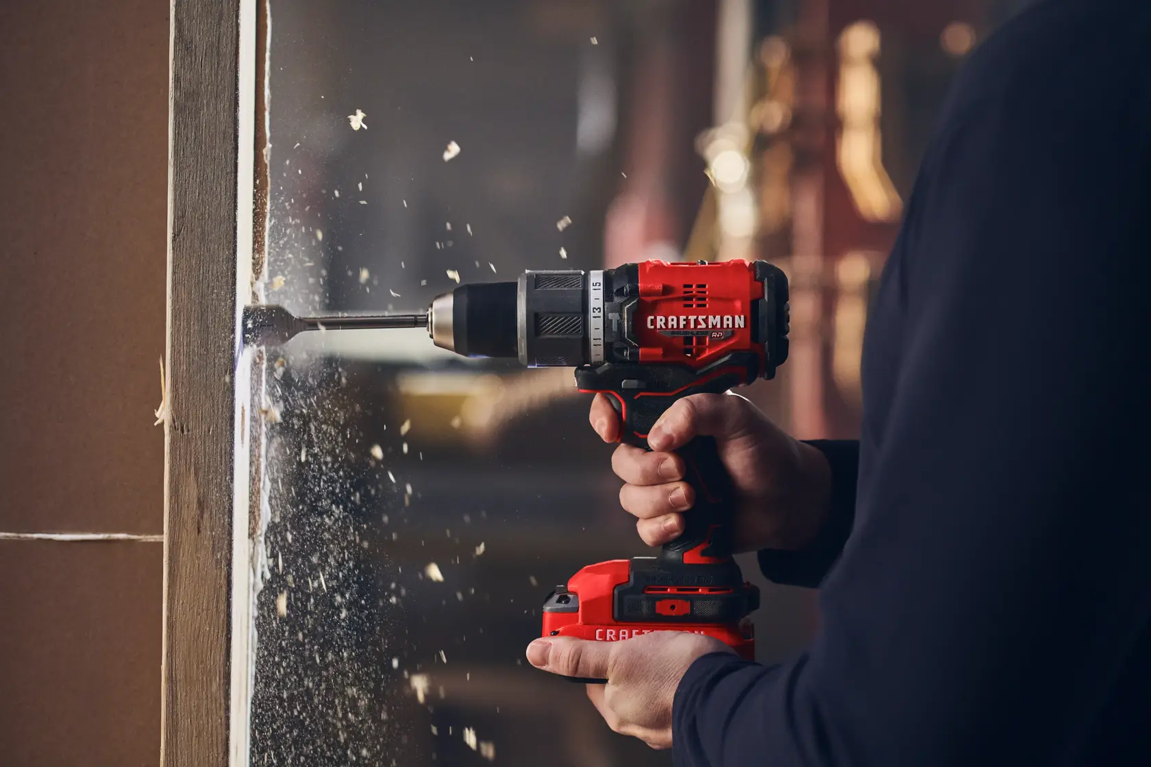 Man in dark shirt drills into wood with CRAFTSMAN V20 drill.