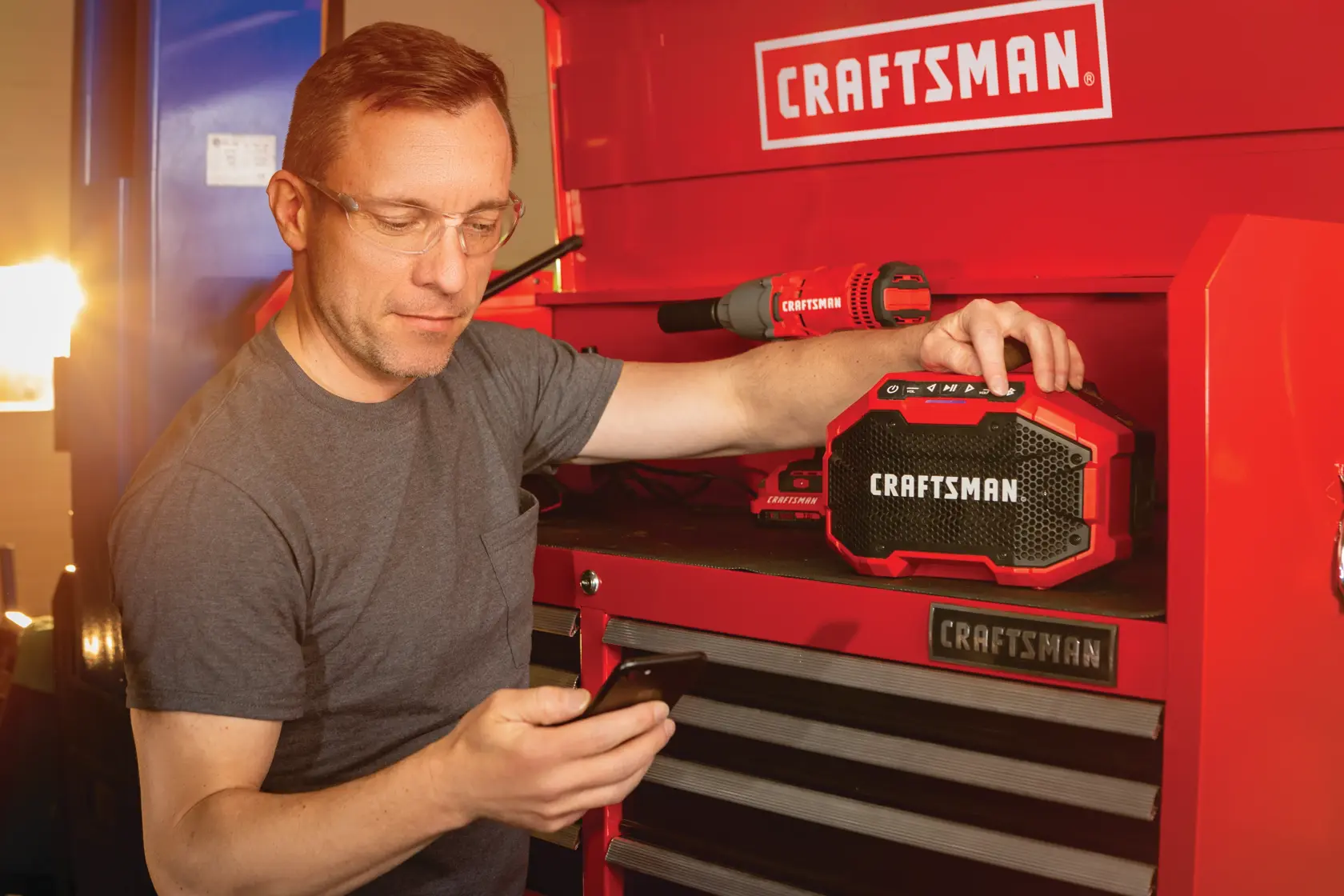20 volt cordless bluetooth speaker being used by a person to connect a smart device to stream music.