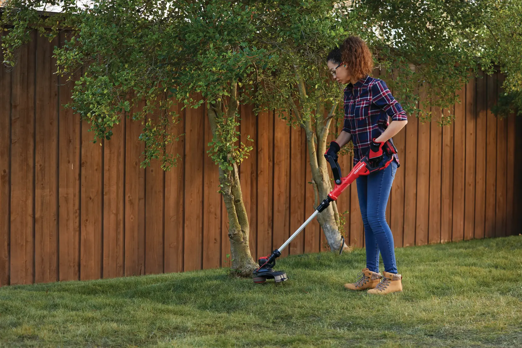 20 volt weedwacker 13 inch cordless string trimmer and edger with automatic feed kit being used by a person to cut grass outdoors.