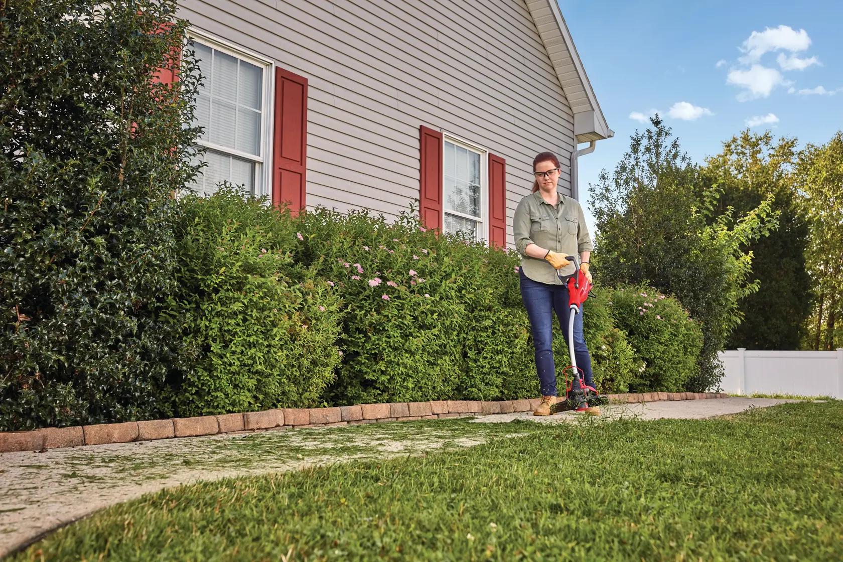 Weedwacker 8.5 amp 14 in corded electric string trimmer being used by a person to trim grass.
