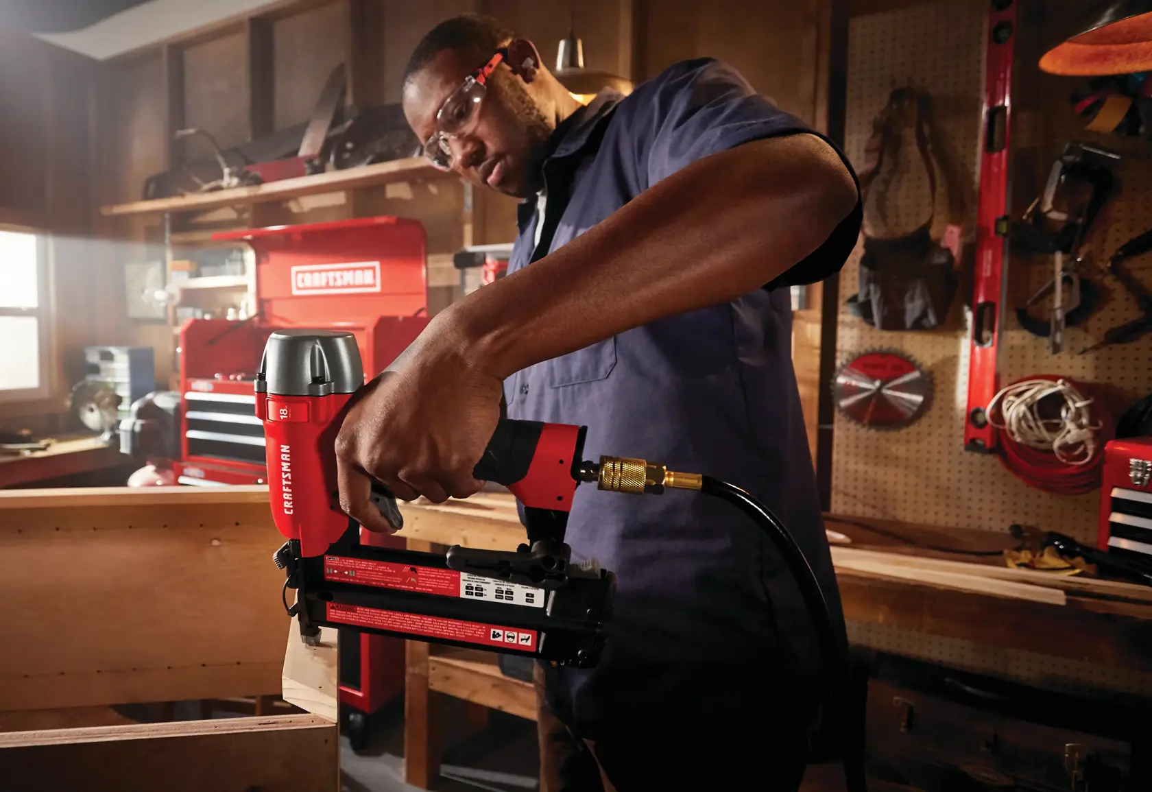18 gauge brad nailer being used to nail a wooden strip by a person.