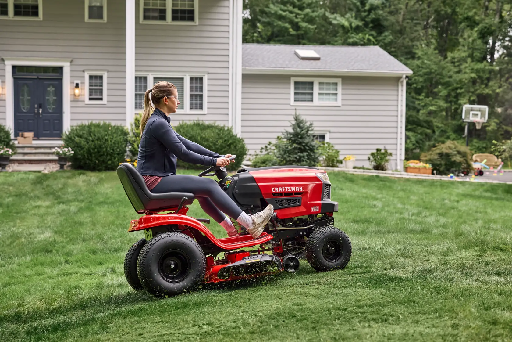 Wide shot cutting grass with the CRAFTSMAN� T150 46-Inch 19 HP Single-Cylinder Gas Riding Lawn Mower