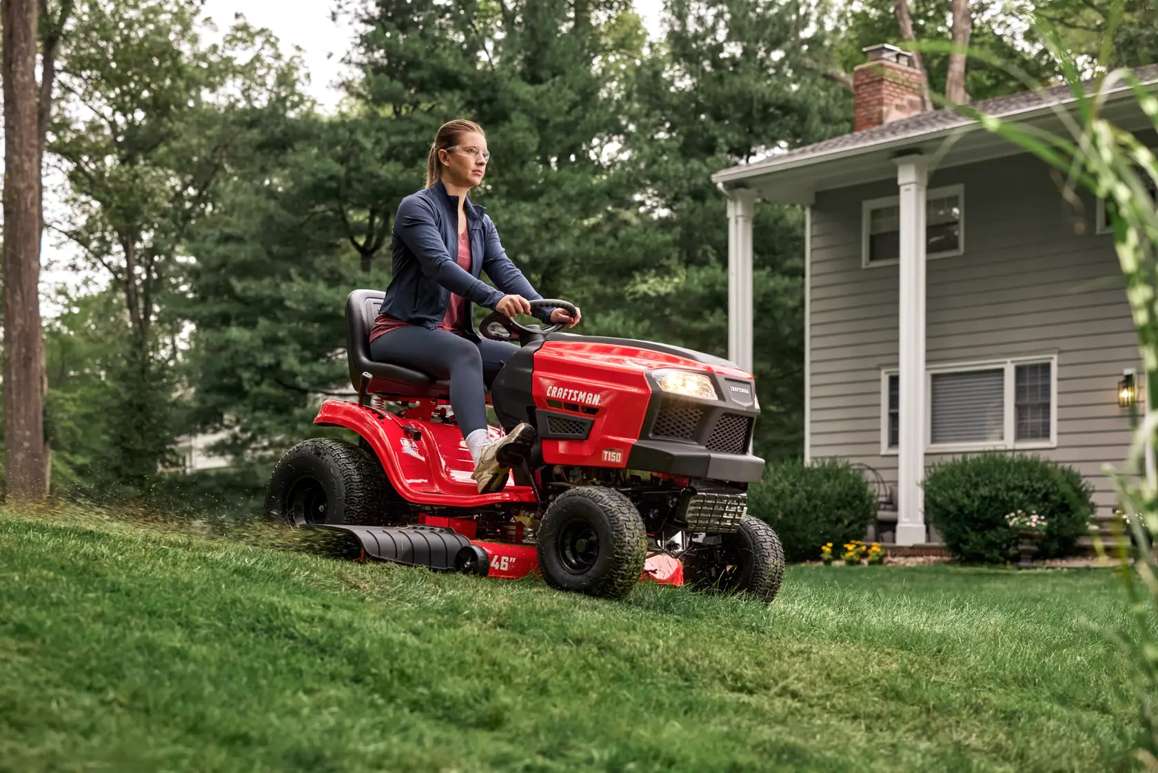 Wide shot cutting grass down a hill with the CRAFTSMAN� T150 46-Inch 19 HP Single-Cylinder Gas Riding Lawn Mower