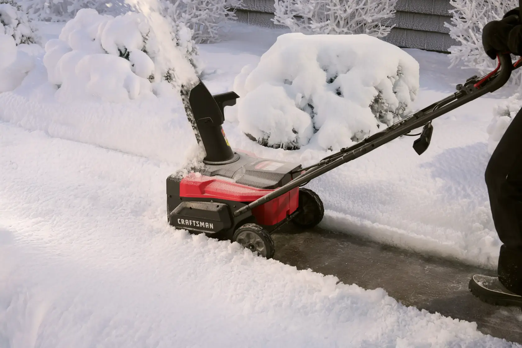 Photo of Craftsman CM32AB2B1CB93 snow blower clearing a snowy sidewalk, side angle view.