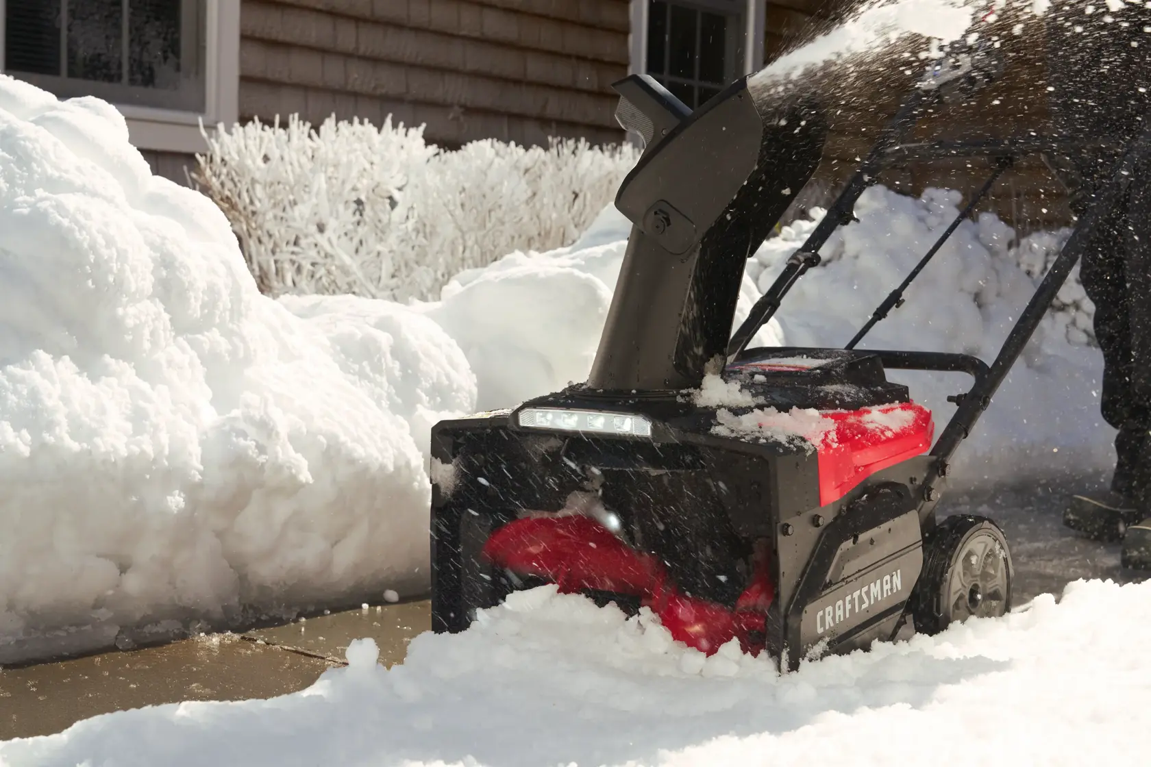 Photo of Craftsman snow blower CM32AB2B1CB93 clearing snow from a driveway, side angle view.