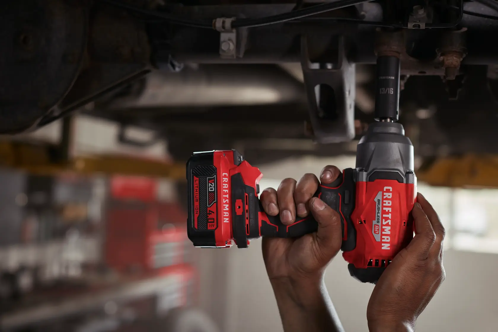 Photo of Craftsman CMCB2046-CK cordless impact wrench in use, red and black design, being operated under a vehicle.