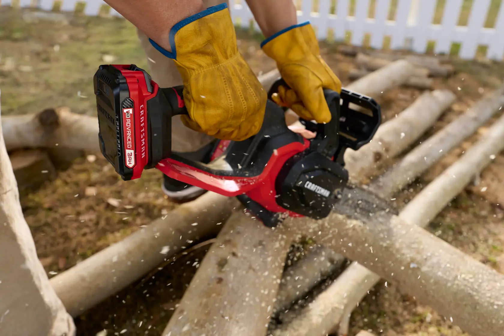 Man using Craftsman 20V chain saw to cut wood