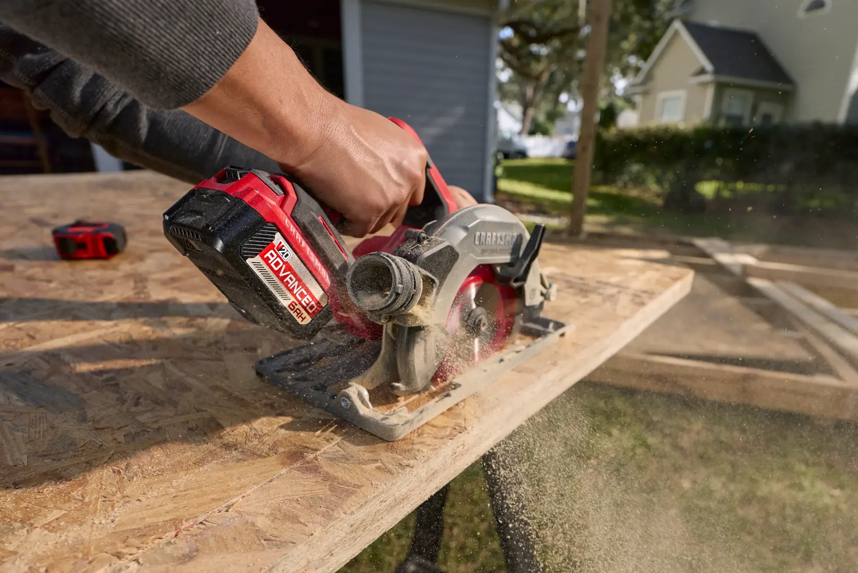 Man uses a Craftsman 20V wood saw to cut through a plank of wood