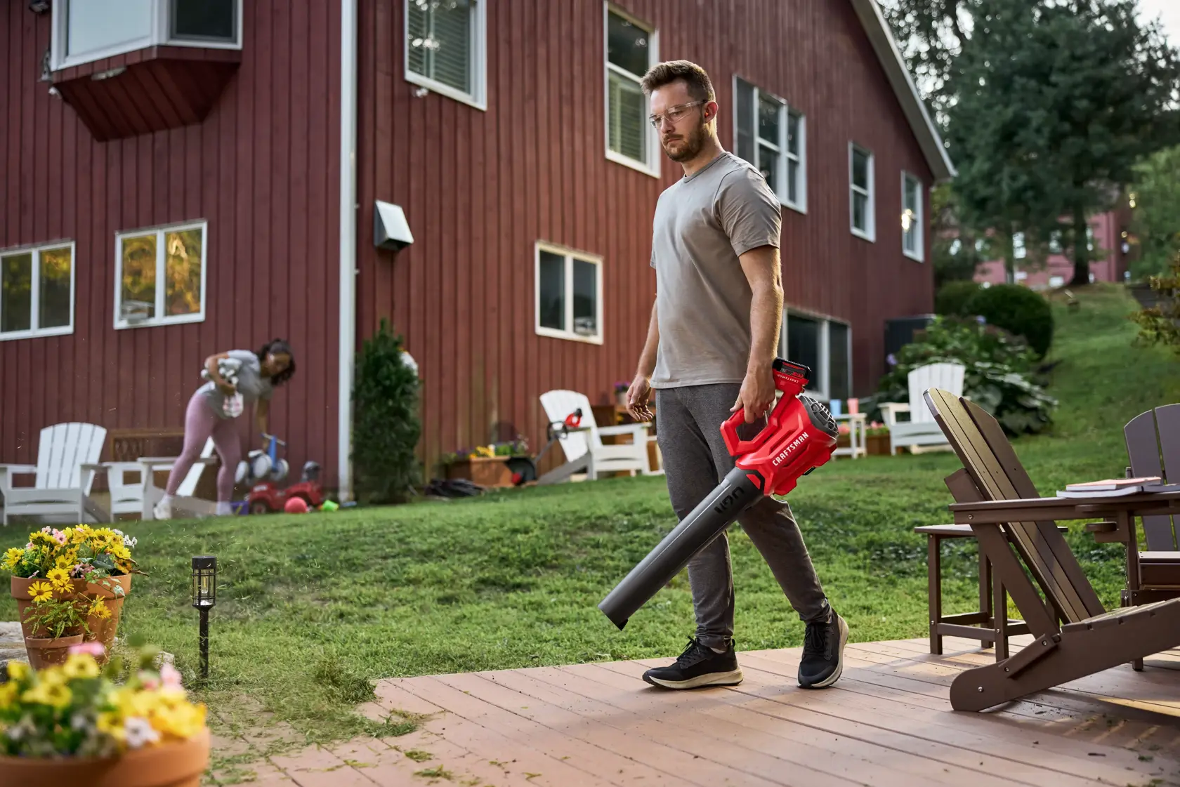 Man blowing grass off patio with the CRAFTSMAN� V20* Cordless Axial Leaf Blower