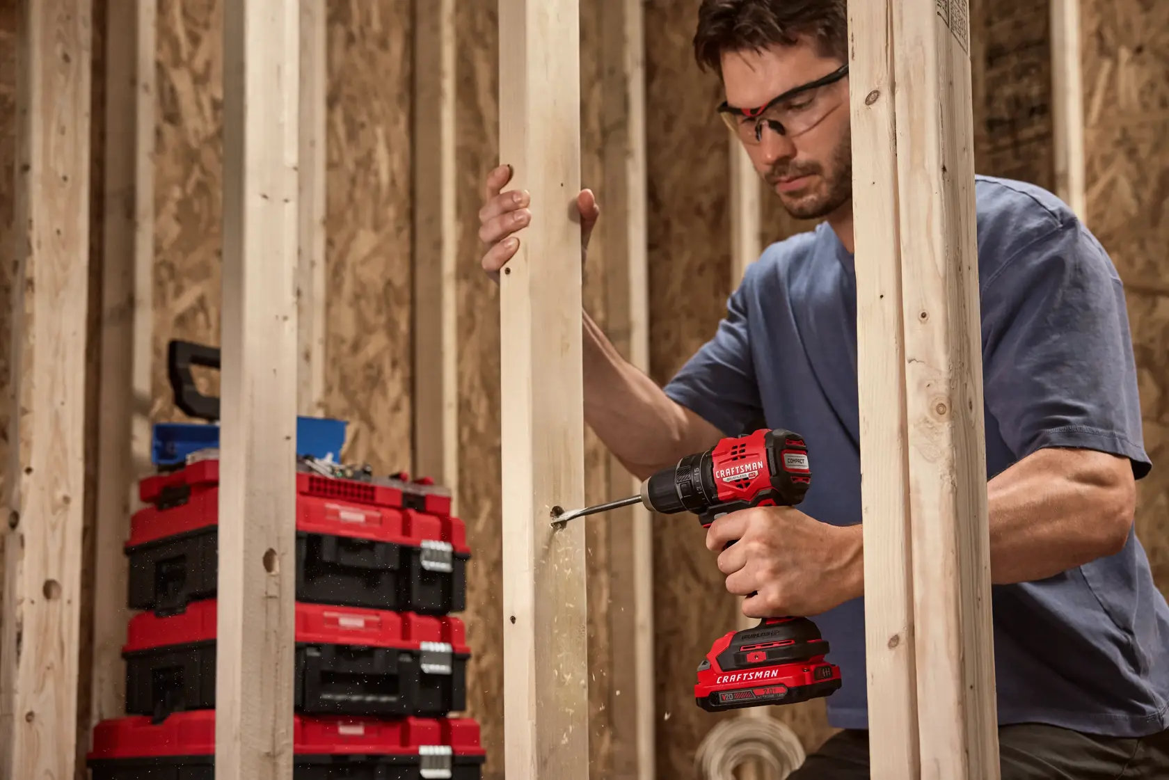 Wide angle of man drilling into frame with CRAFTSMAN® V20* BRUSHLESS RP™ Compact Drill/Driver on the VERSATRACK™. Additional Items Pictured Not Included