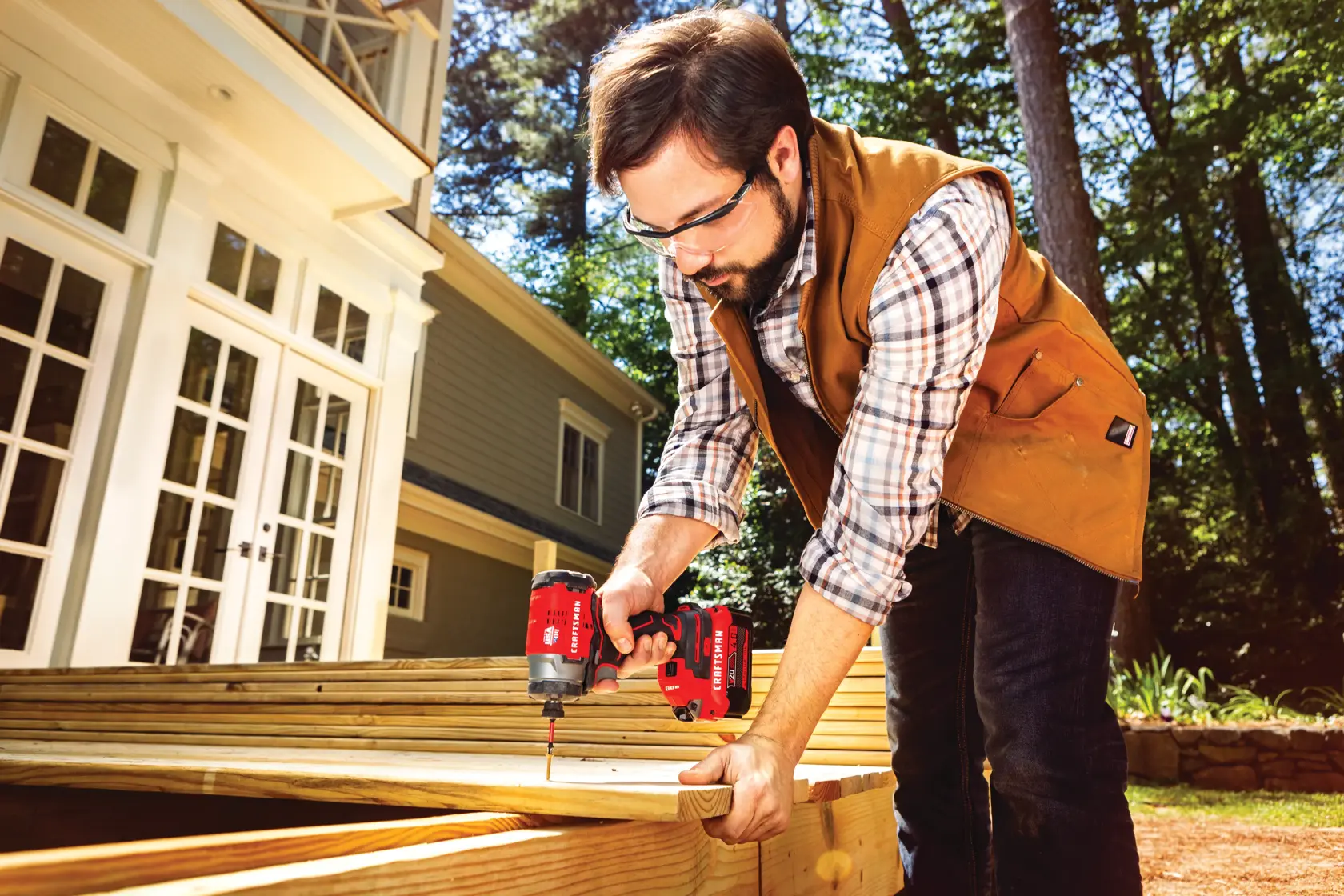 Brushless cordless impact driver 2 batteries being used to drive in screws by person.
