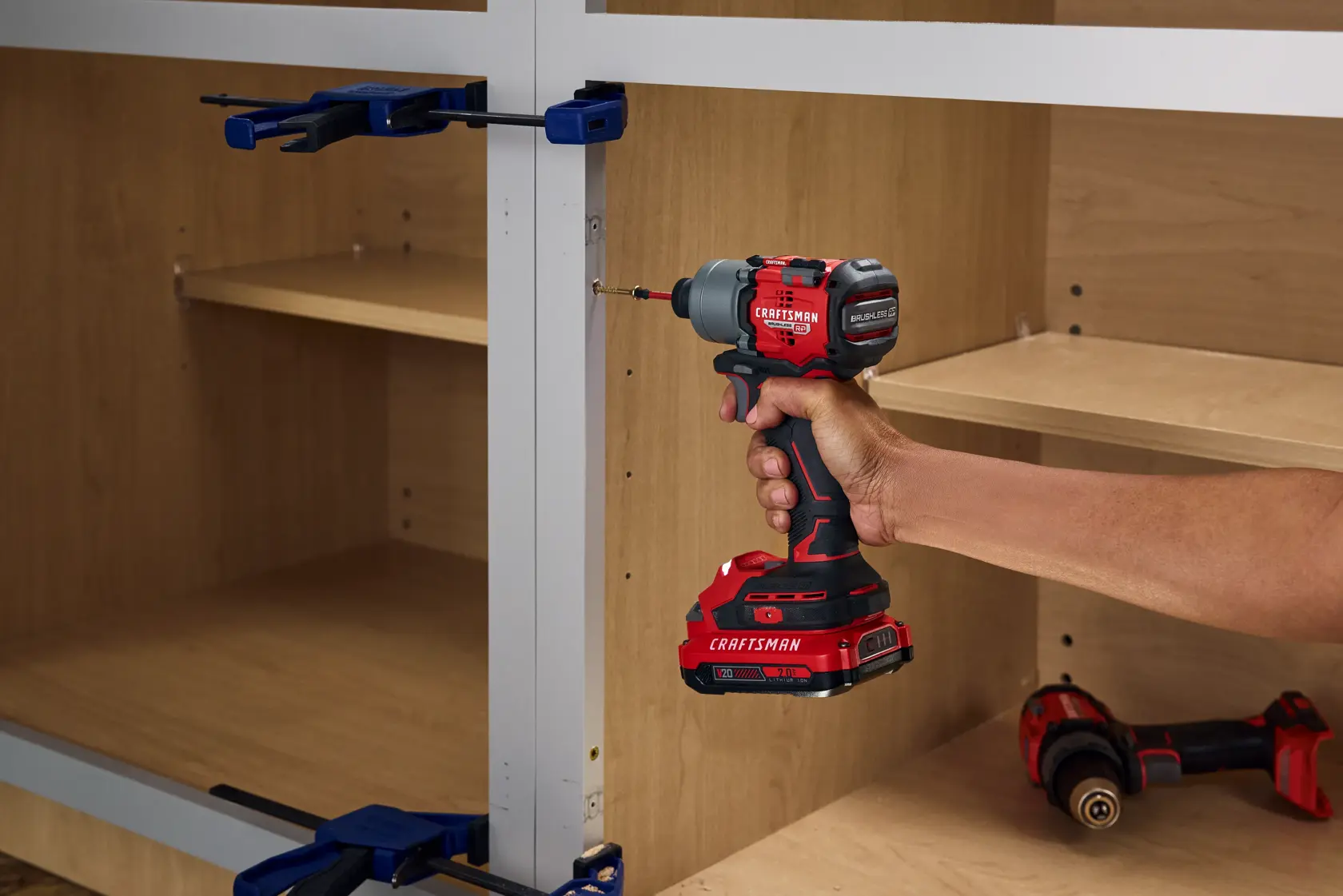 Photo of Craftsman CMCF830D2 cordless impact driver in use, driving a screw into a cabinet assembly.