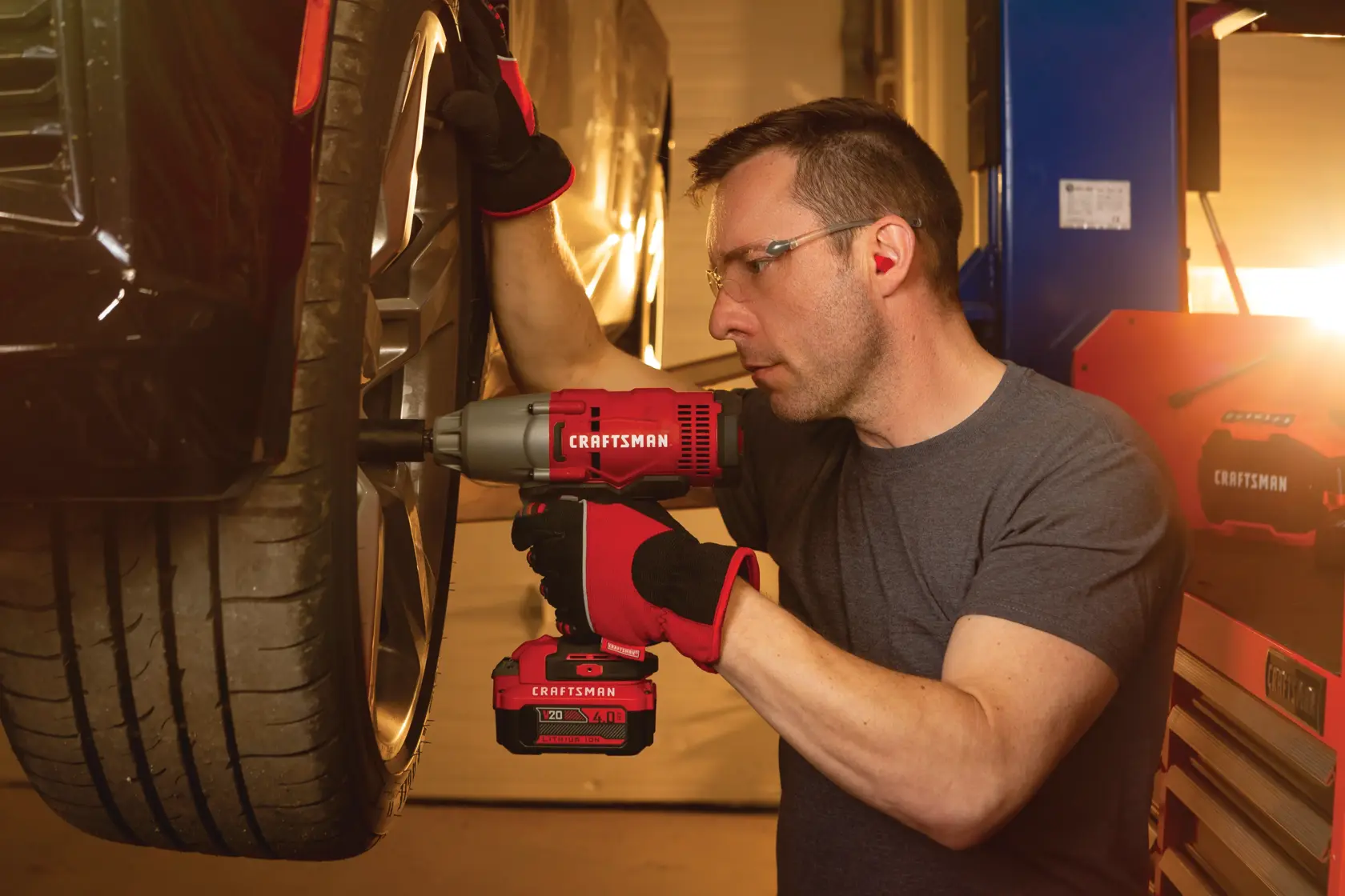 Cordless half inch impact wrench kit 1 battery being used to tighten tyre screws by person.