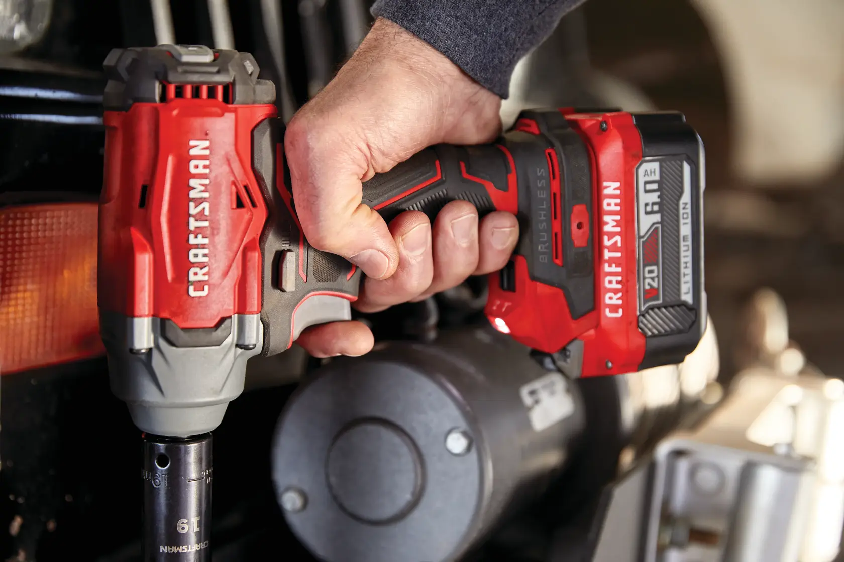 Photo of Craftsman cordless impact driver CMCF920B in use, red and gray design, automotive context.