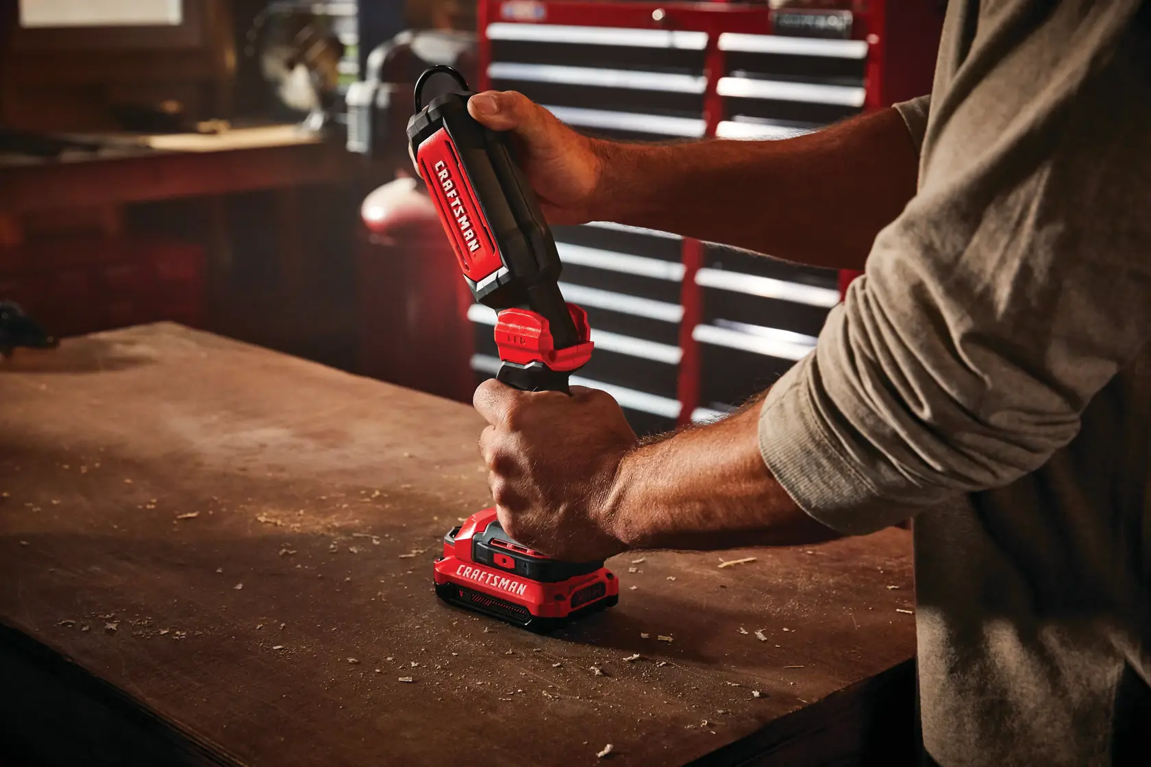 Cordless led hanging work light tool only being held by person.