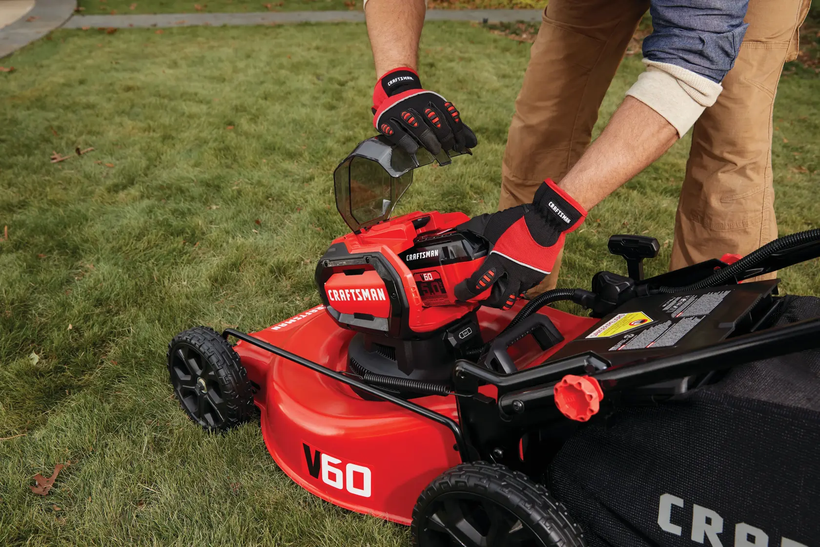 Cordless 21 inch 3 in 1 lawn mower kit 5 amp hour battery being placed.