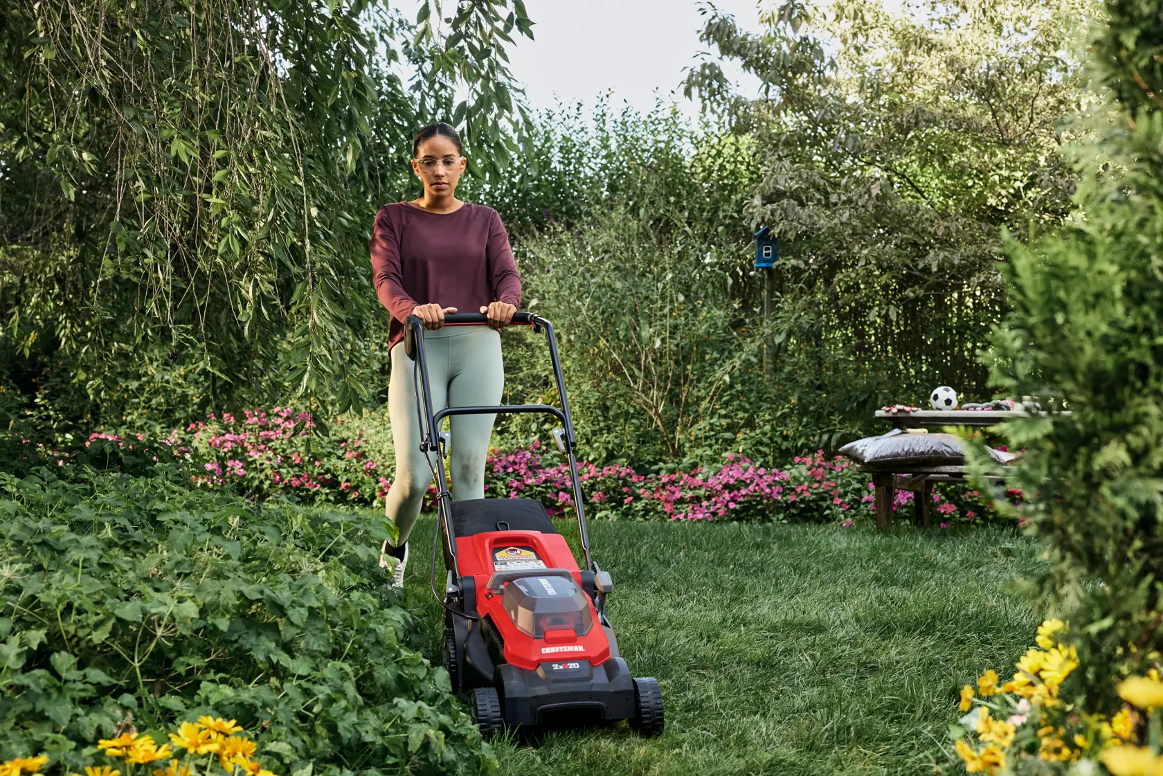 Woman mowing on a smaller lot size with the CRAFTSMAN� 2xV20* 15 IN. PUSH MOWER KIT