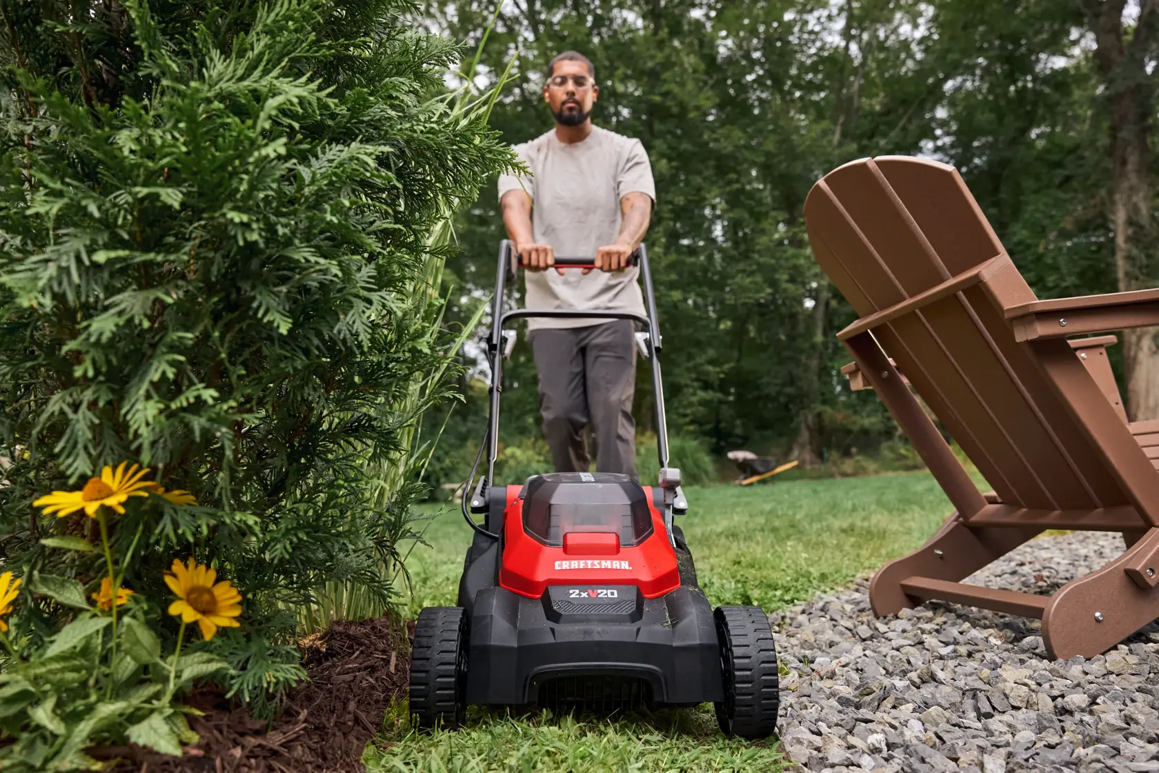 Man mowing in a tight area with the CRAFTSMAN® 2xV20* 15 IN. PUSH MOWER KIT