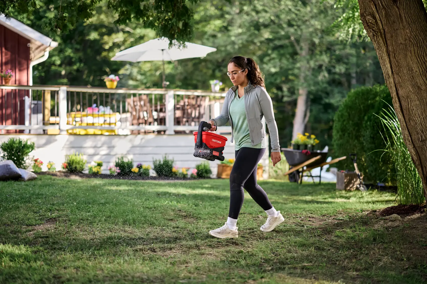 Woman seeding grass with the CRAFTSMAN� V20* 4 Season Seeder Spreader Tool Only