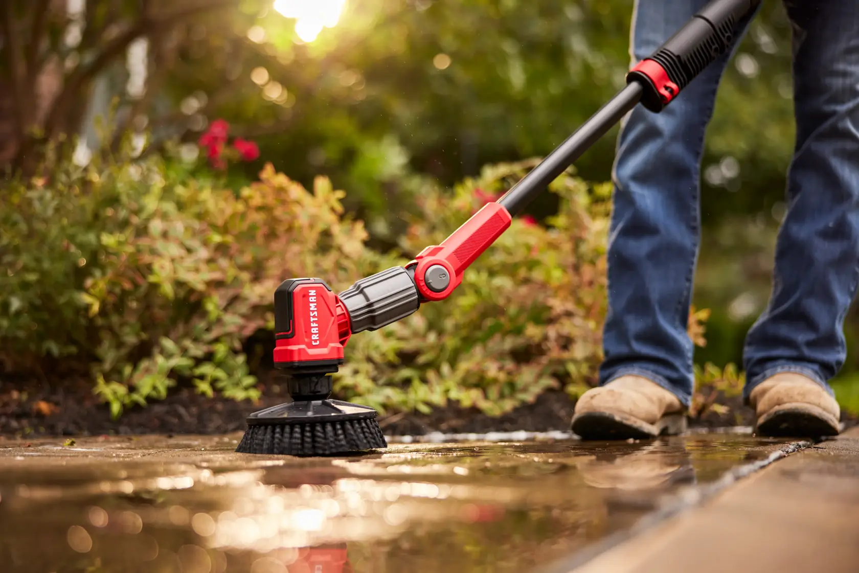 Side view of male cleaning outdoor patio ground with V20 Scubber 