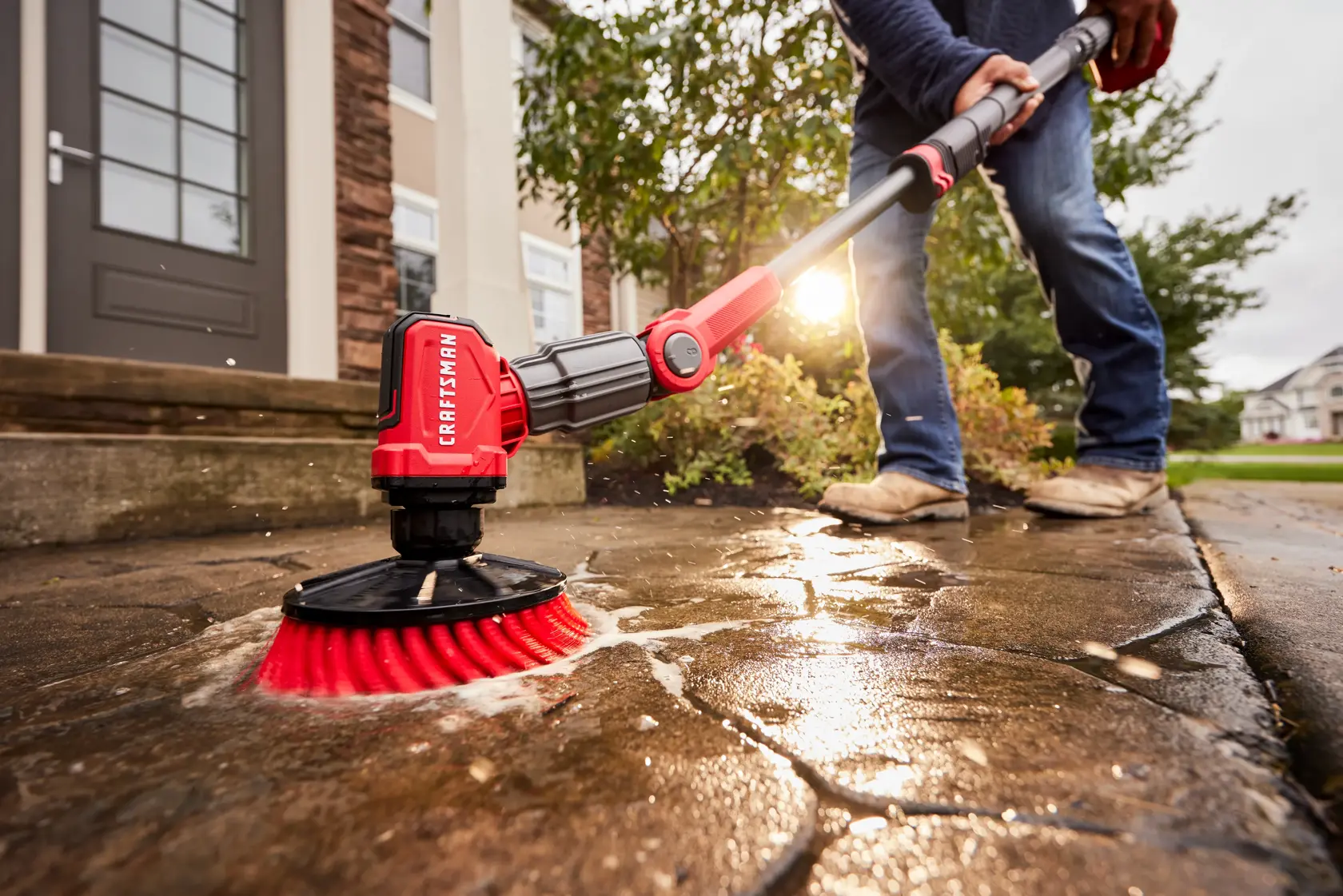 Side view of male cleaning outdoor patio ground with V20 Scubber 