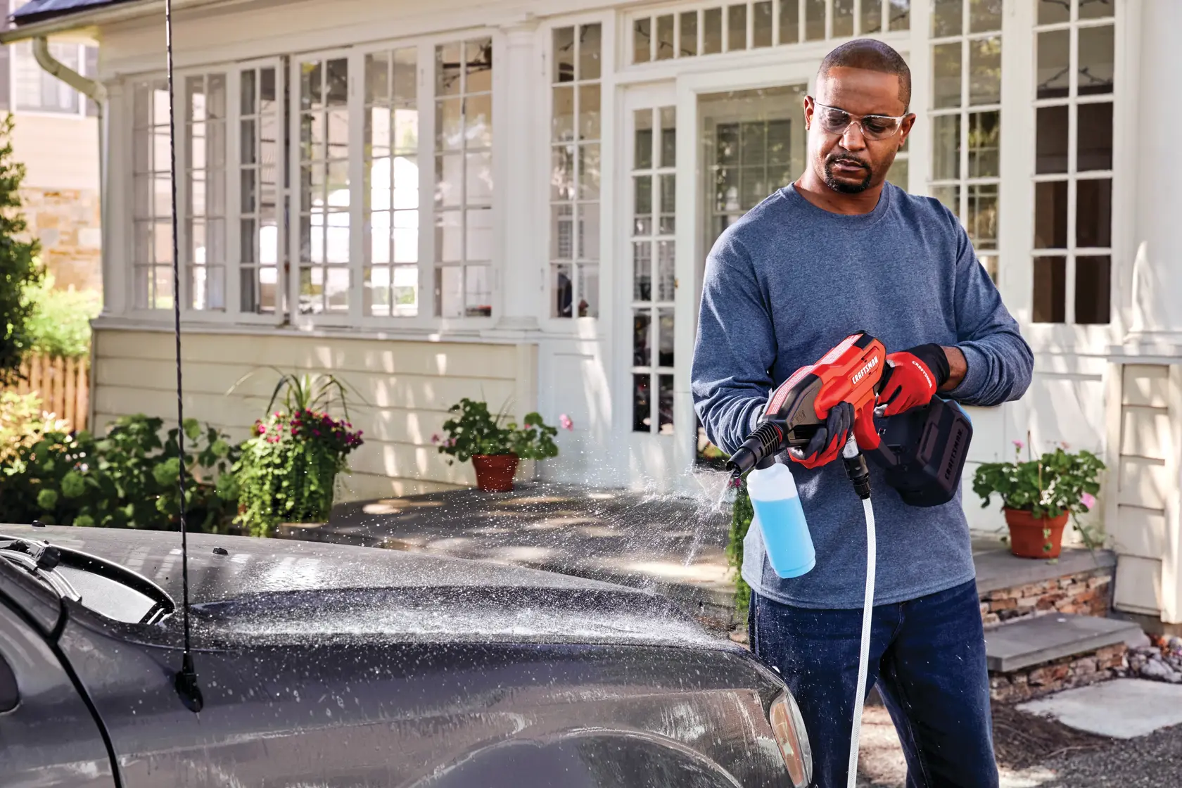 20 volt cordless 350 max P S I power cleaner kit being used by a person to clean a car outdoors.