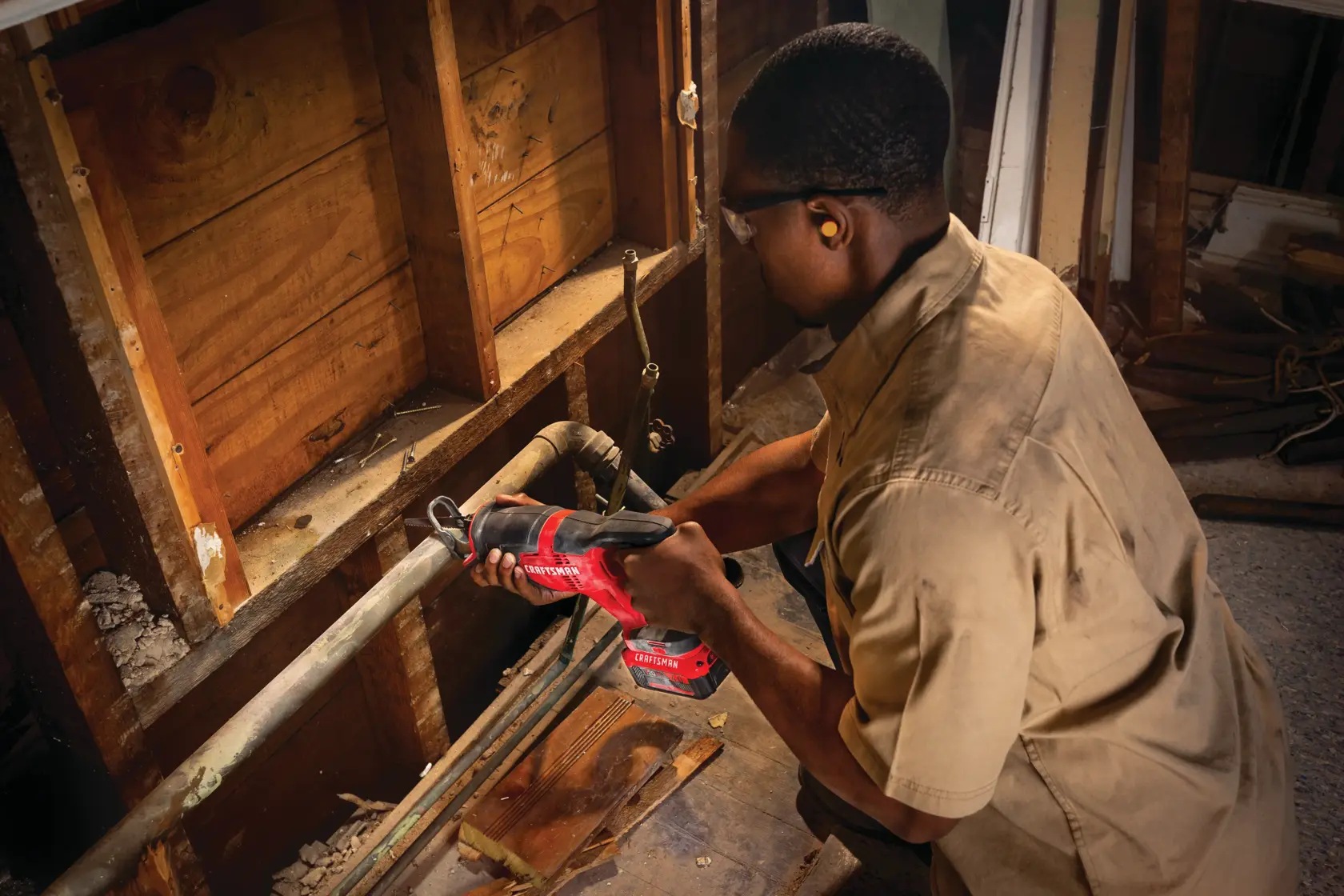 20 volt cordless reciprocating saw kit being used by a person to cut a steel pipe.