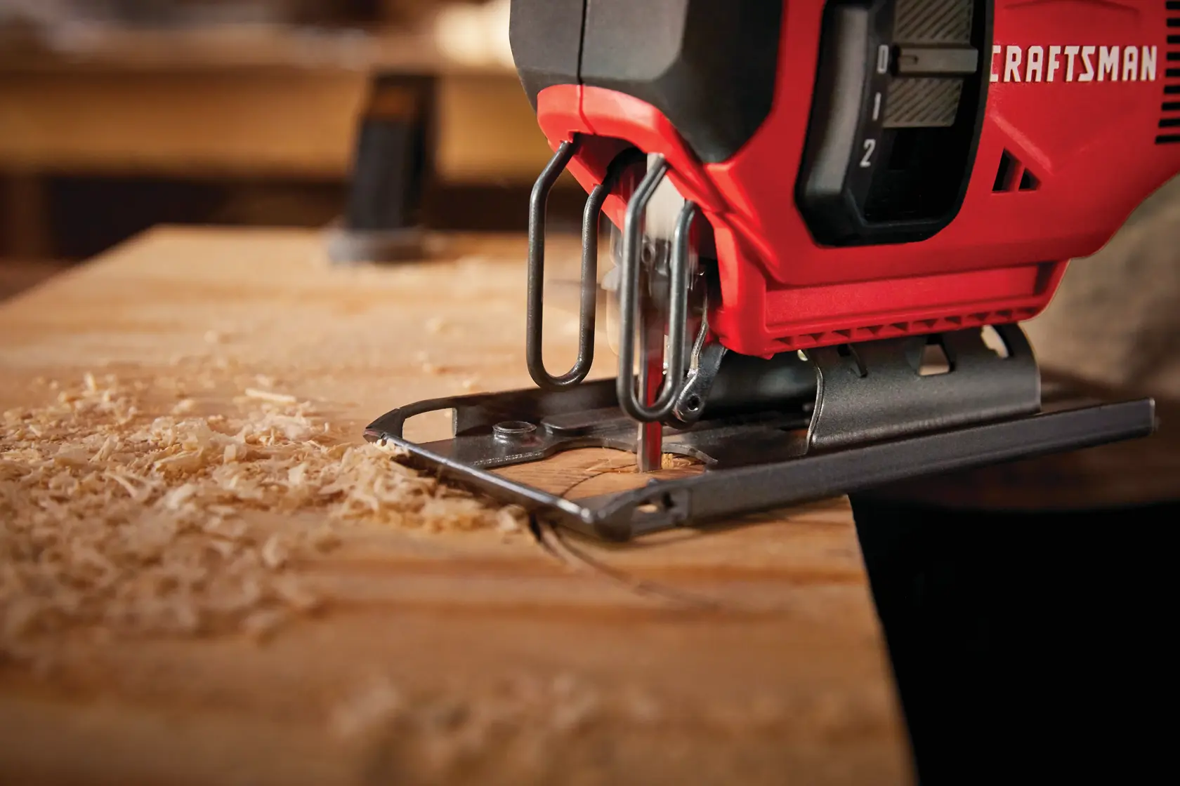 20 volt cordless jig saw kit being used by a person to cut a semi circle on wood.