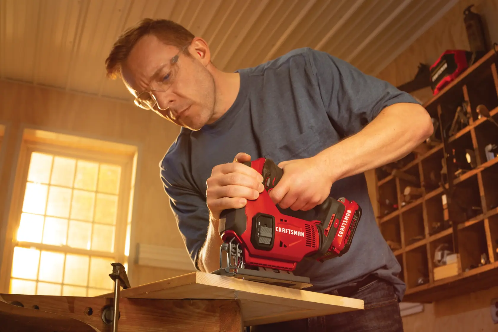 20 volt cordless jig saw kit being used by a person to cut wood at a workshop.