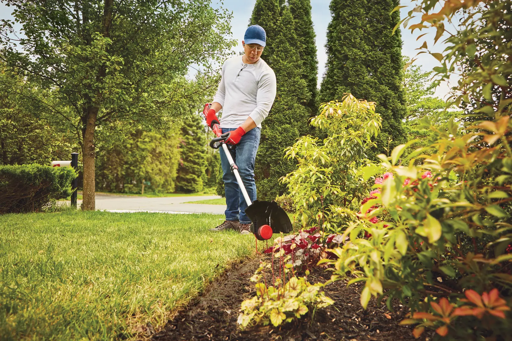 20 volt cordless 13 inch weedwacker string trimmer edger with push button feed being used by a person to trim grass outdoors.