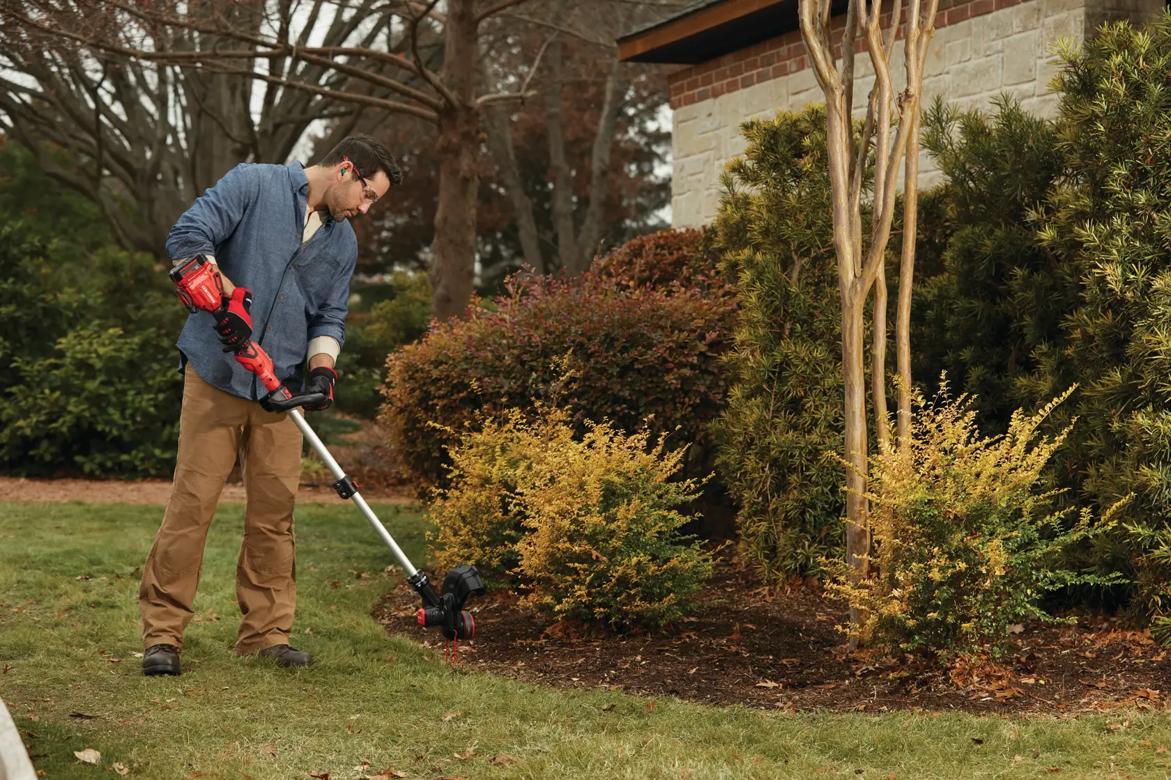 20 volt weed wacker 13 inch cordless string trimmer and edger with push button feed kit being used by a person to cut weed outdoors.