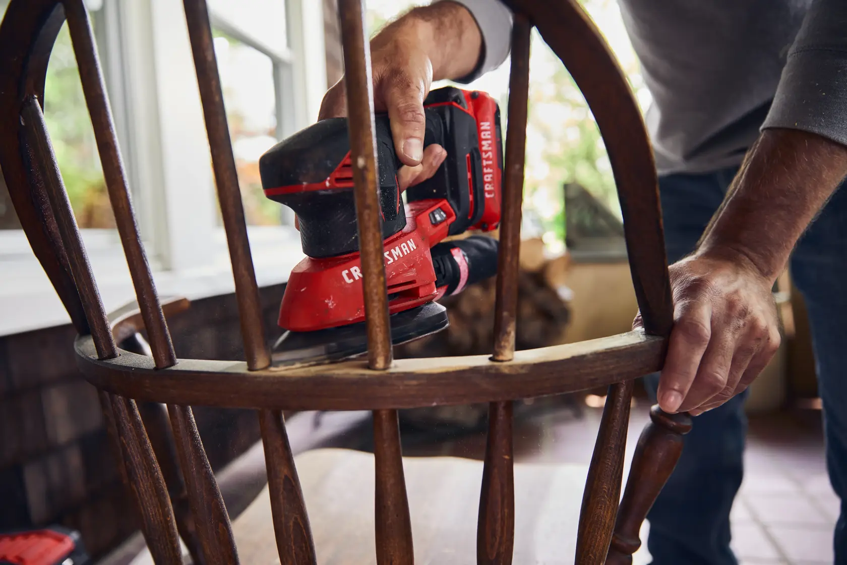 20 volt cordless detail sander being used.