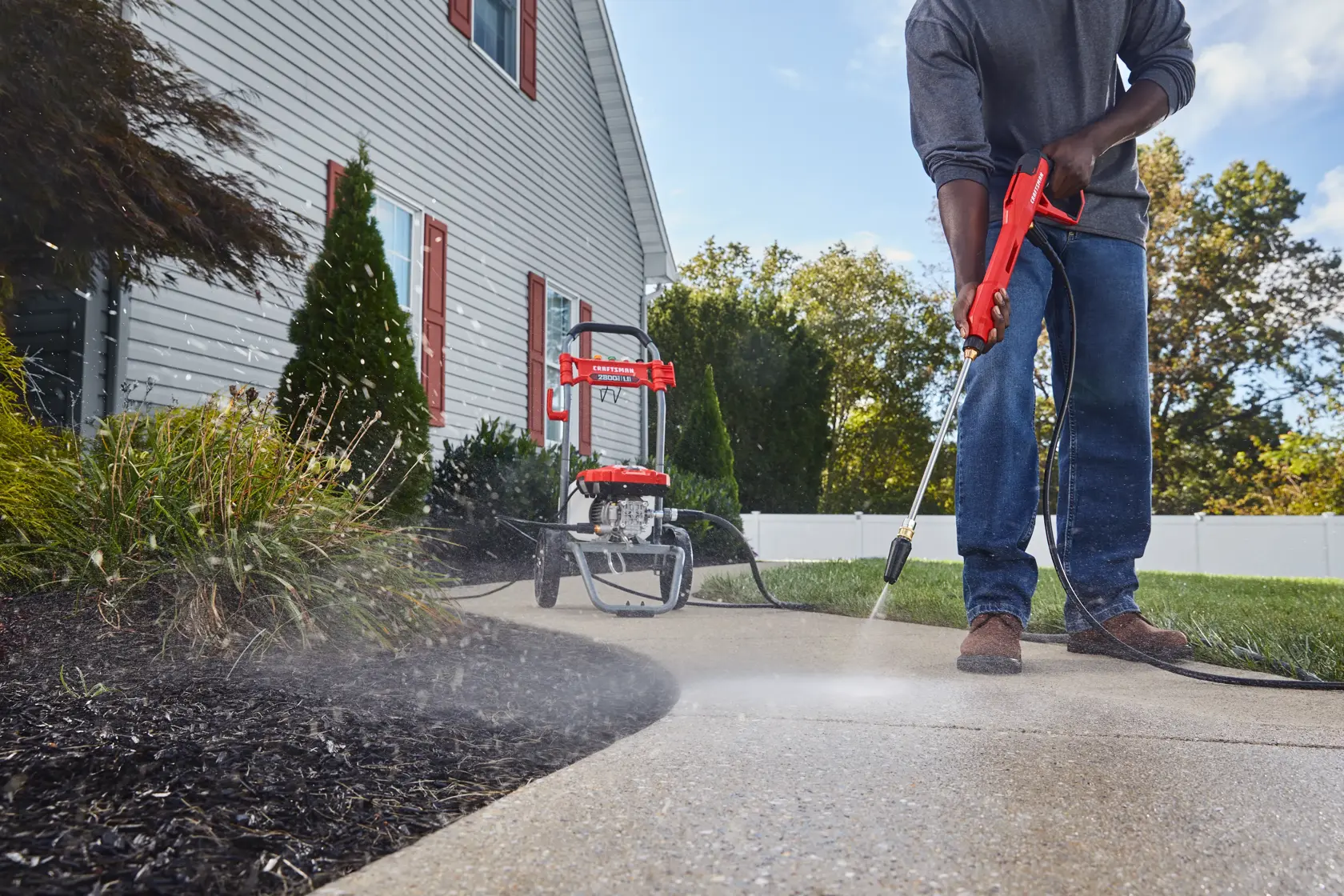 CRAFTSMAN 2800 Pressure Washer pressure washing sidewalk with flowerbed in background