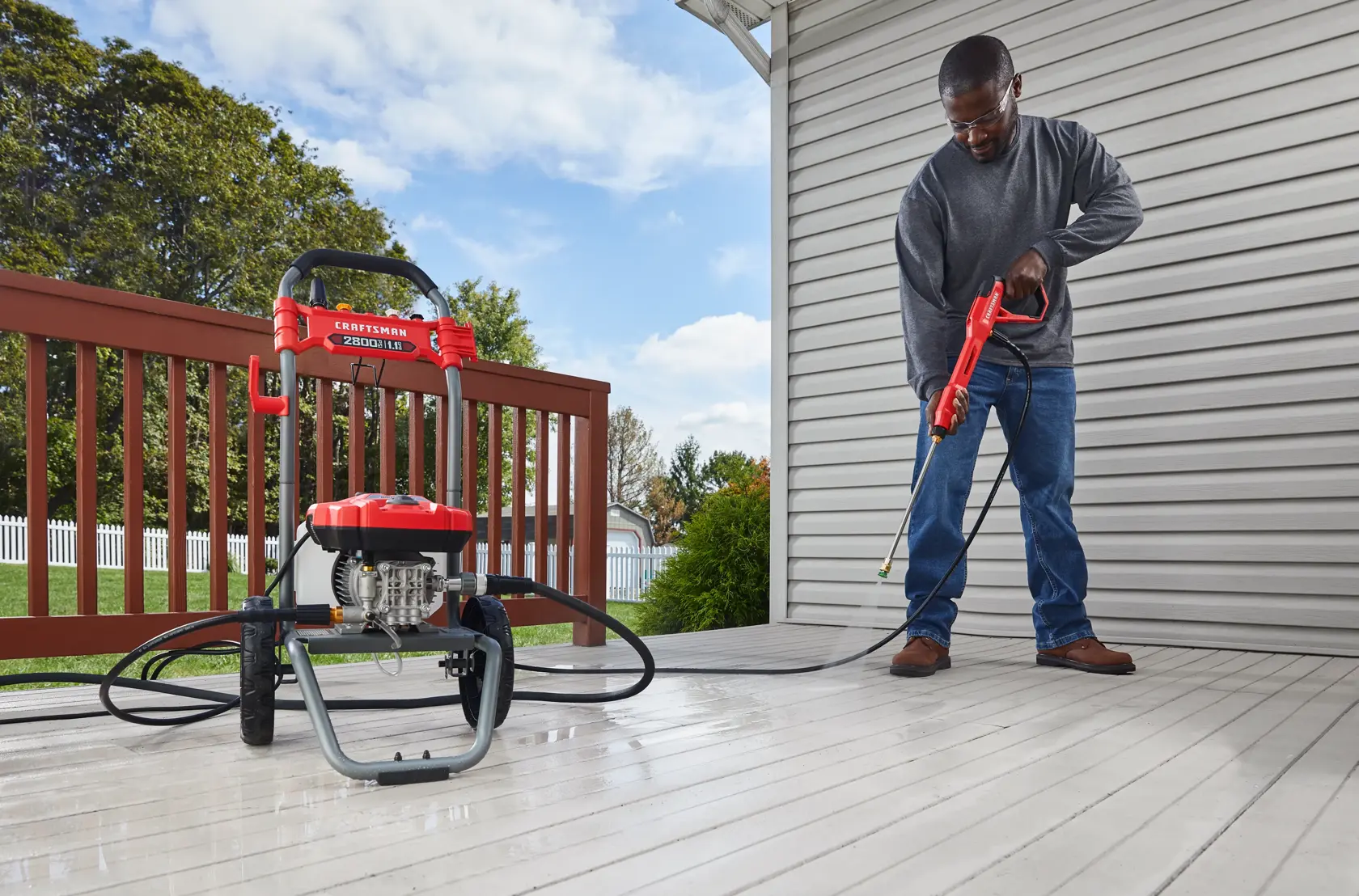 CRAFTSMAN 2800 Pressure Washer pressure washing outside deck with shed and trees in background