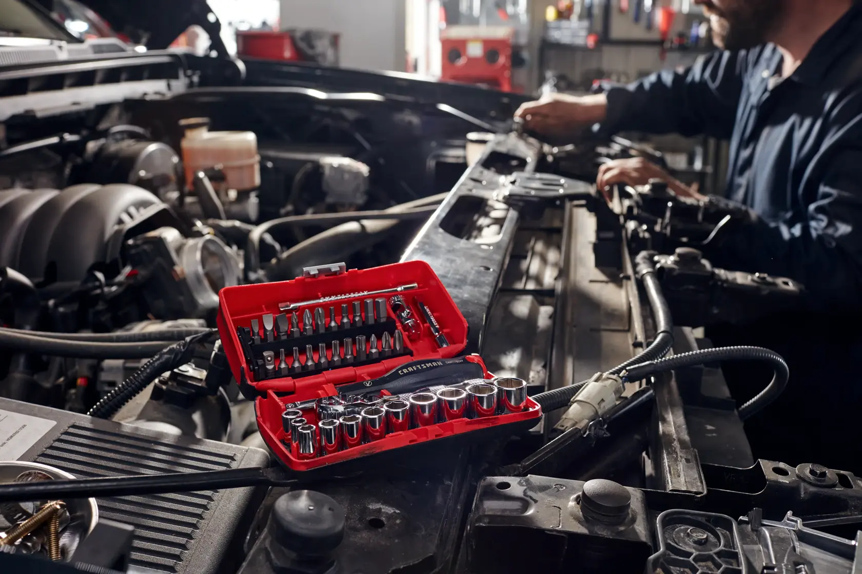 1 quarter inch drive metric 6 point tool set being used by a person to fix a car.