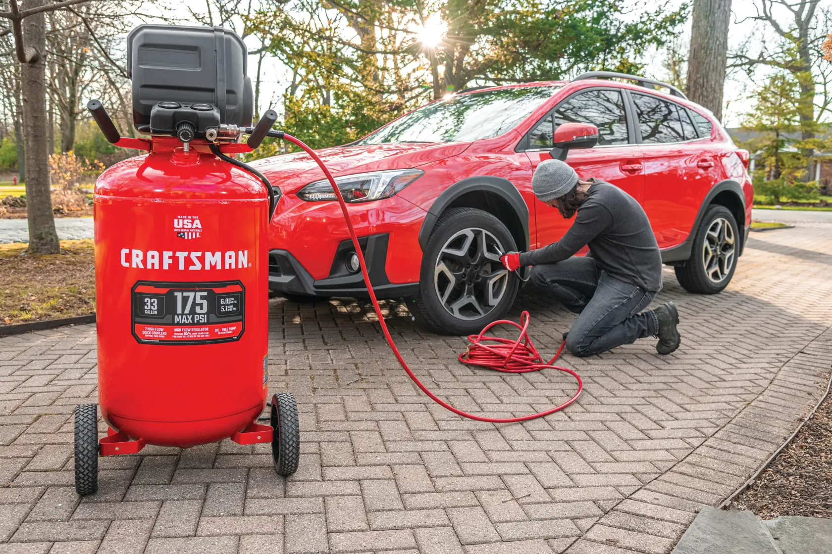 33 gallons 175 p s i oil free portable vertical air compressor being used for inflating .