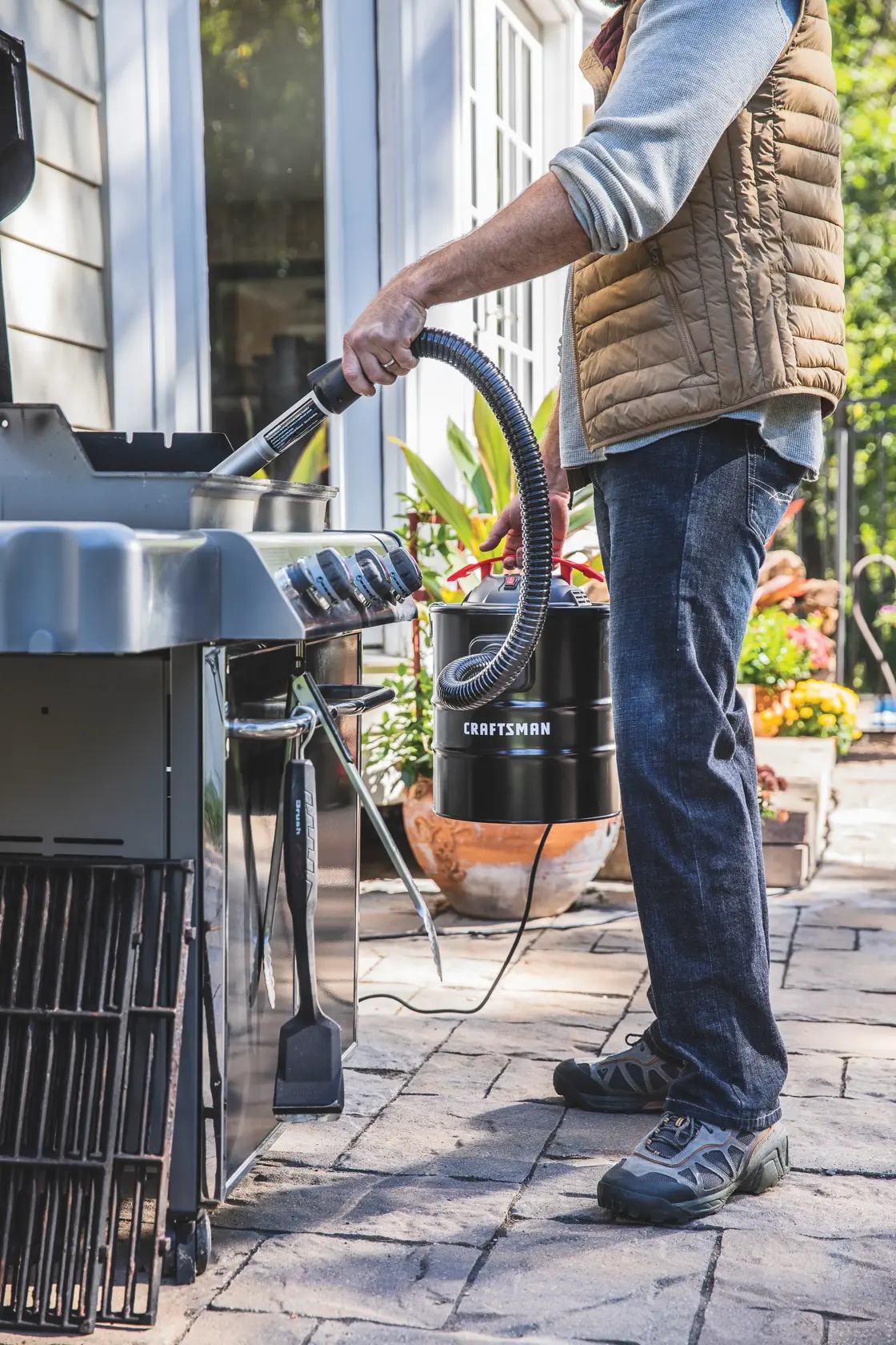5 gallon 3.0 Peak h p ash vacuum being used to clean hard to reach areas of stove.