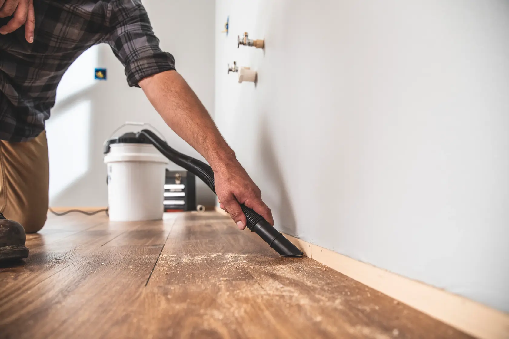 1.75 peak H P powerhead bucket head wet dry vacuum being used by a person to clean wooden floor.