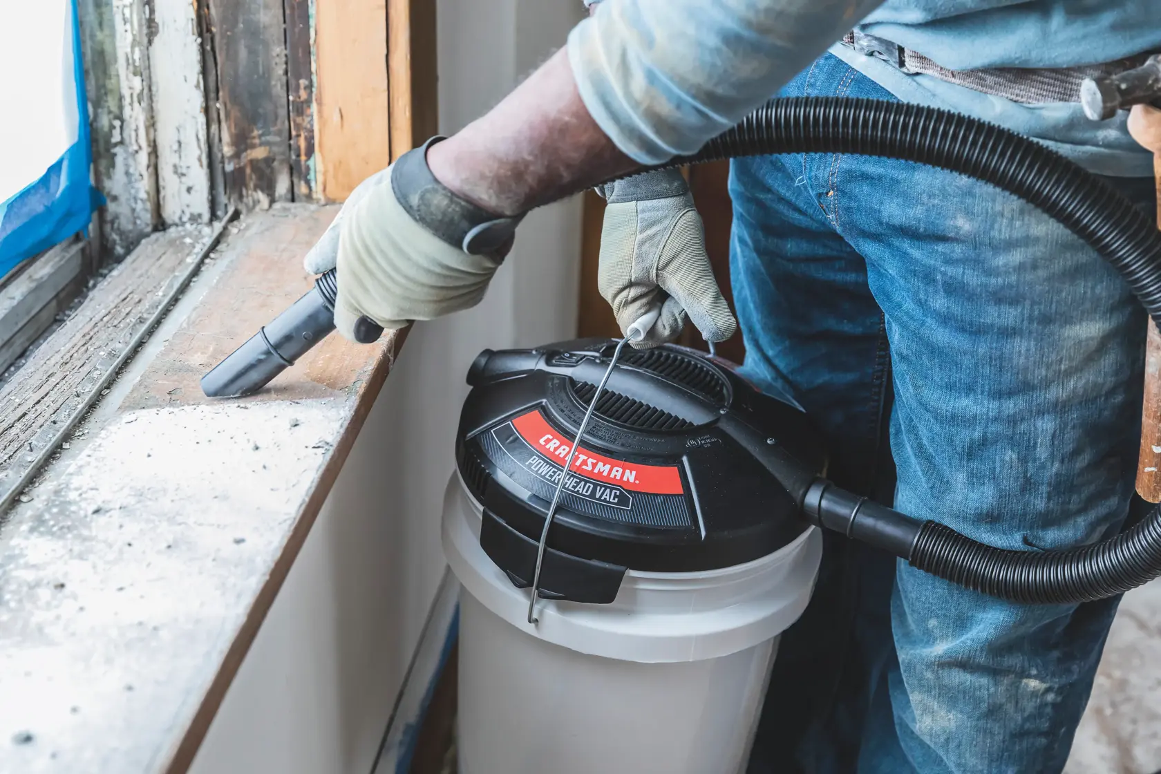 1.75 peak H P powerhead bucket head wet dry vacuum being used by a person to clean window frame.
