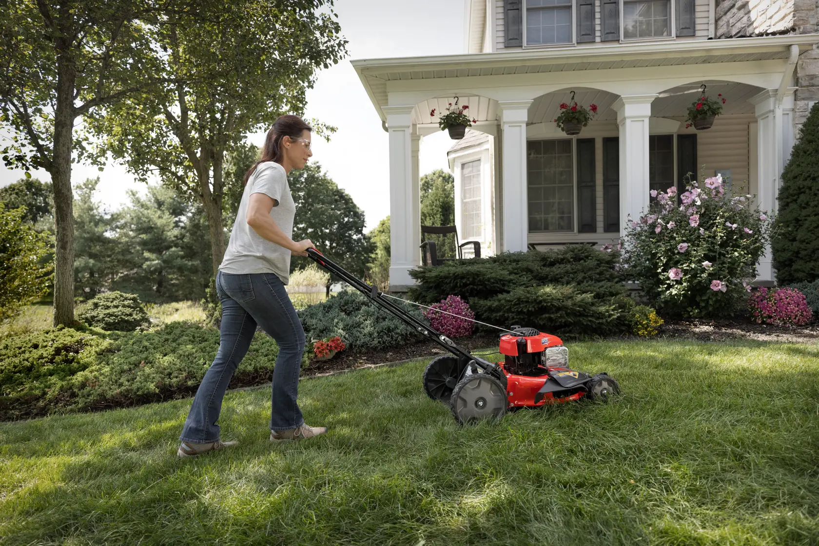 CRAFTSMAN 140cc Push Mower in top view being emptied with maroon shirt 